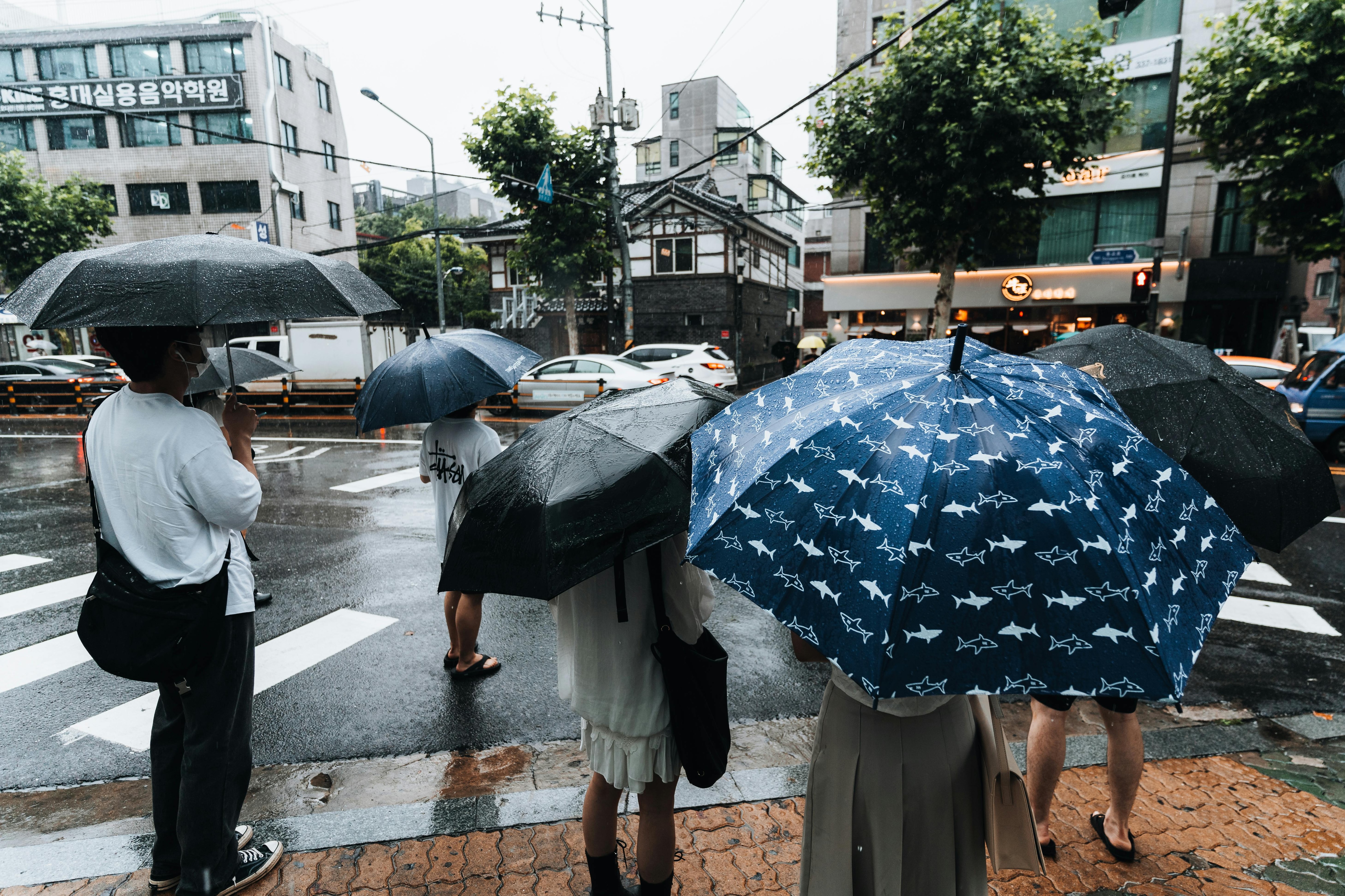 People stand with umbrellas amid heavy rain. (Photo: PTI)