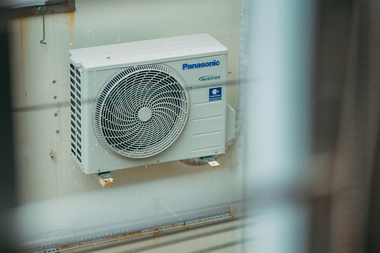 Air conditioner unit mounted outdoors on a building wall. (Photo: Pexels)