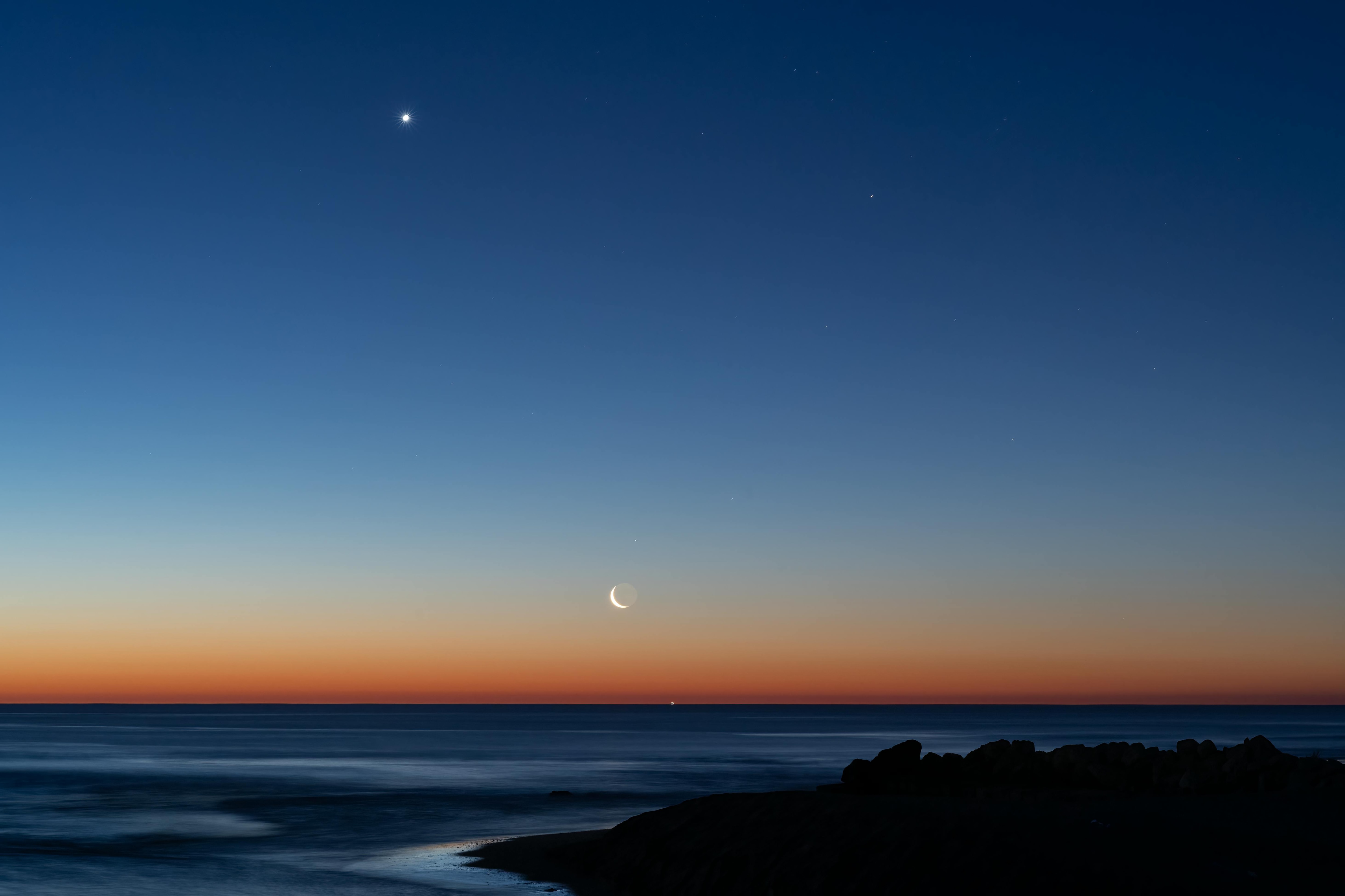Captivating view of crescent moon and planets aligning over the ocean at twilight near Valencia, Spain. (Photo: Pexels)