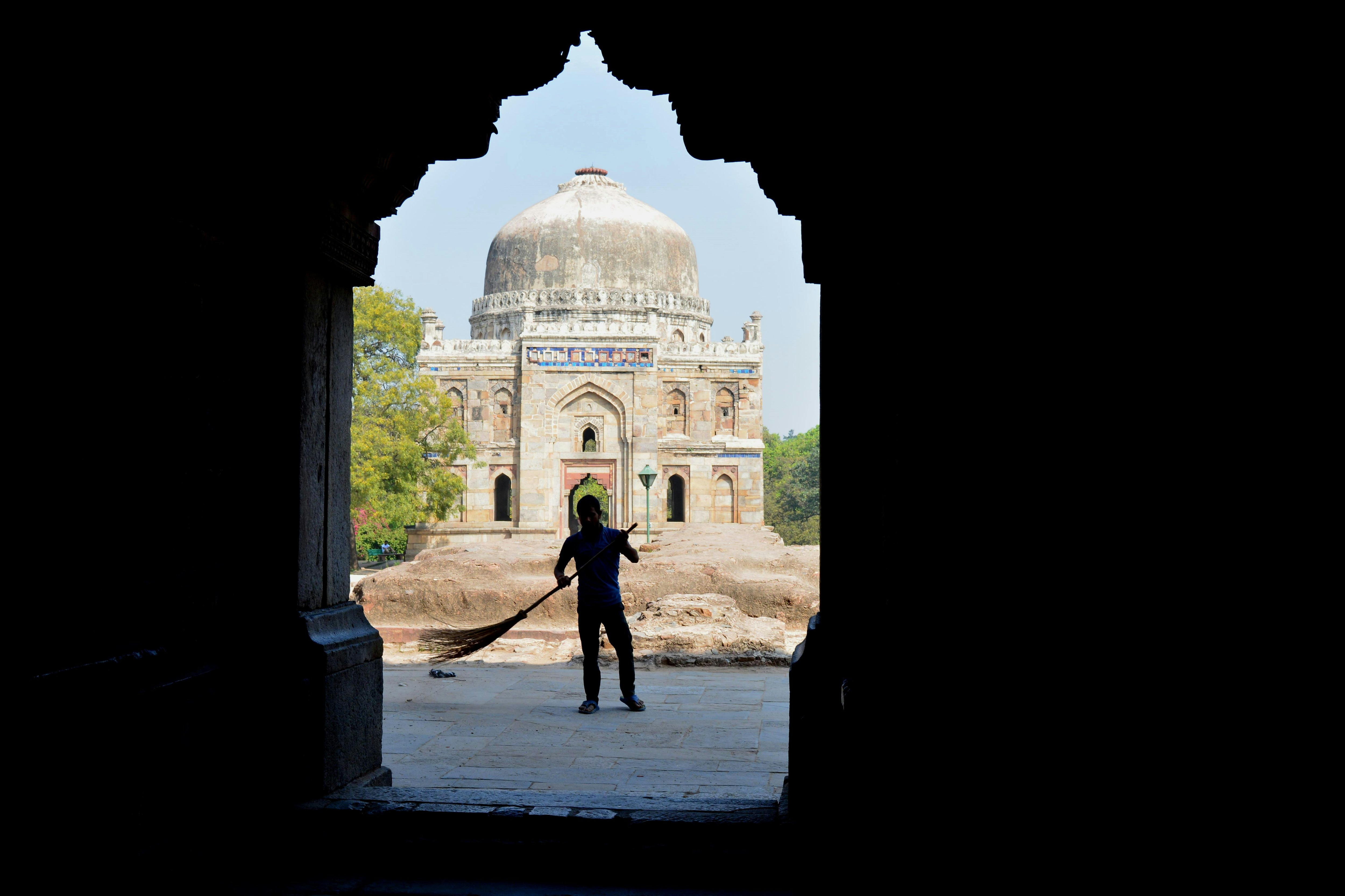 Silhouette of a person sweeping in Lodhi Garden, New Delhi, on a hot day. (Photo: PTI)
