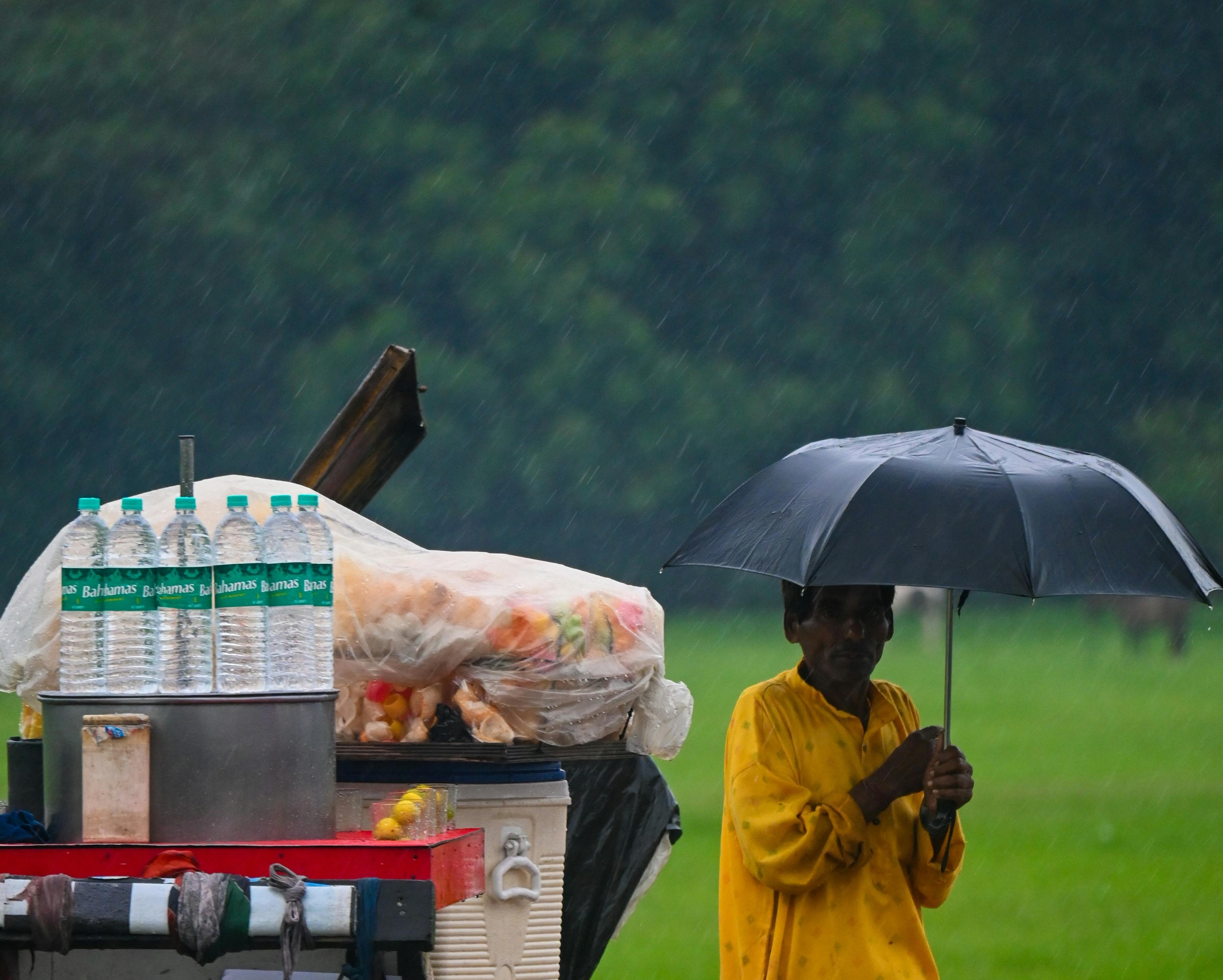 A street vendor is seen standing with an umbrella on a rainy day in Delhi. (Photo: Pexels)