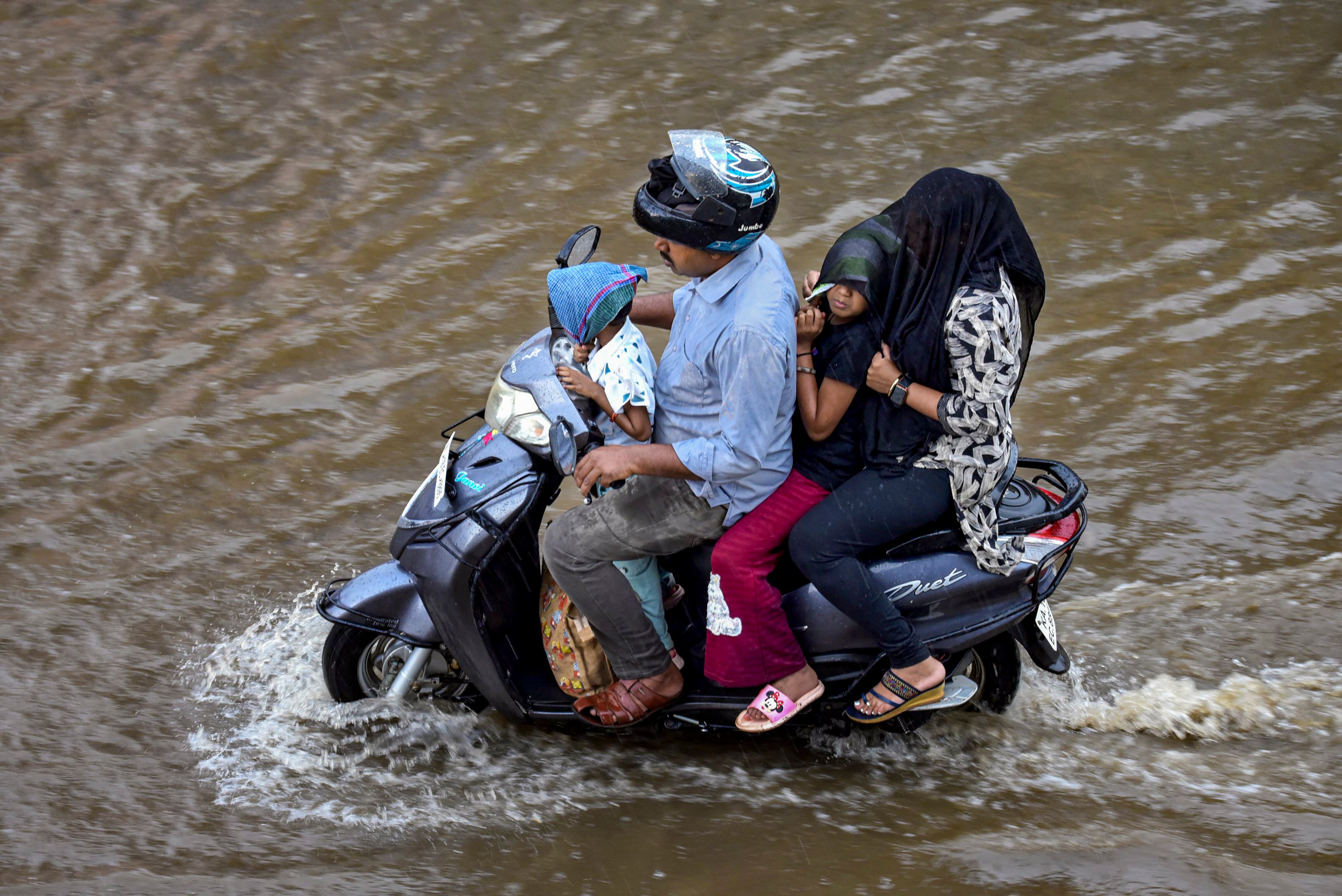 Commuters wade through a flooded road. (Photo: PTI)