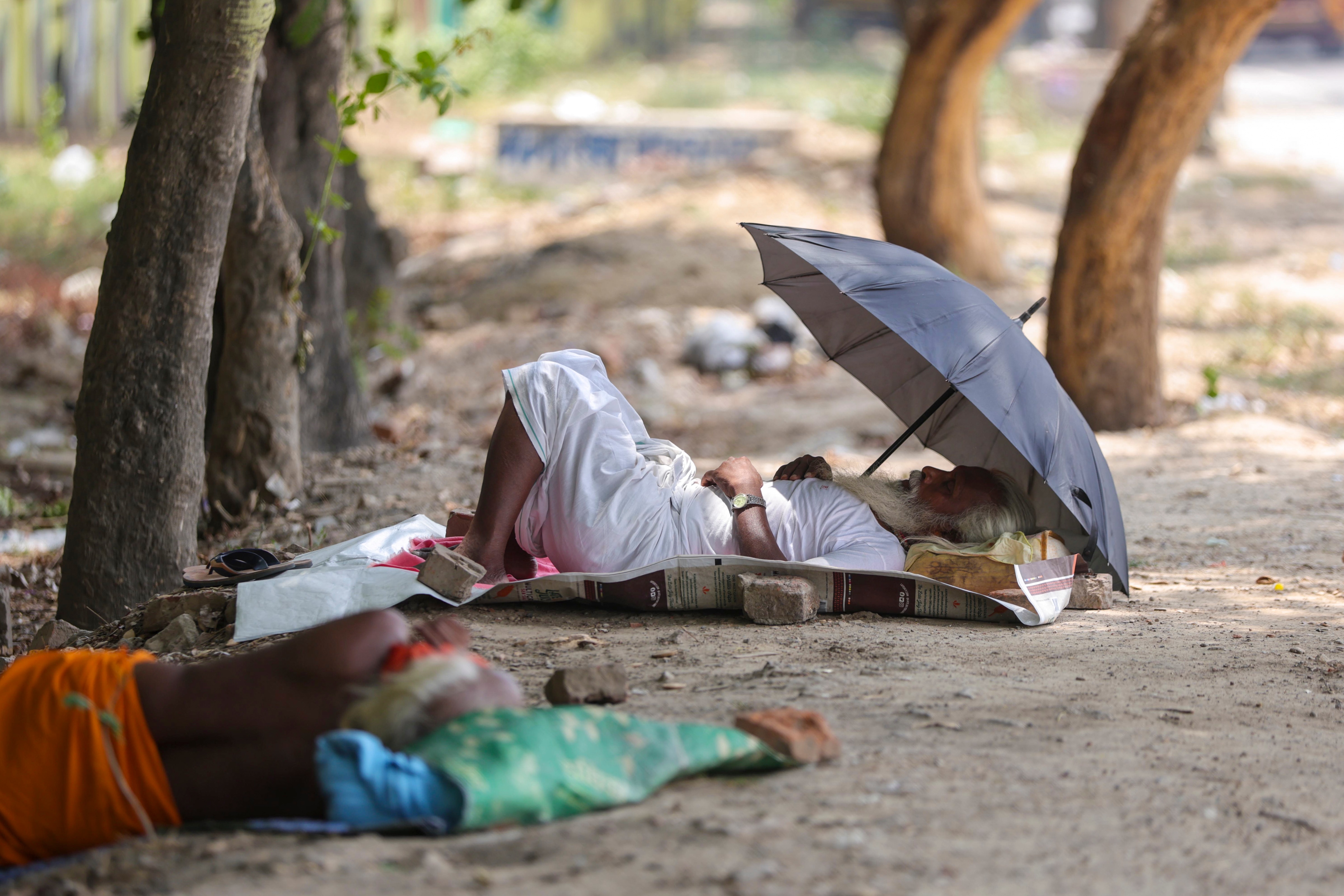 A man covers himself with an umbrella during a hot day in Surat, Gujarat. (Photo: PTI)