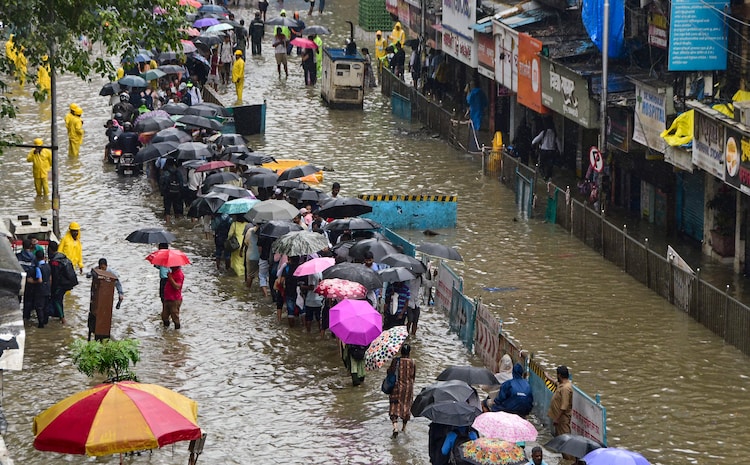 Commuters move through a waterlogged street in Parel, Mumbai. (Photo: PTI)