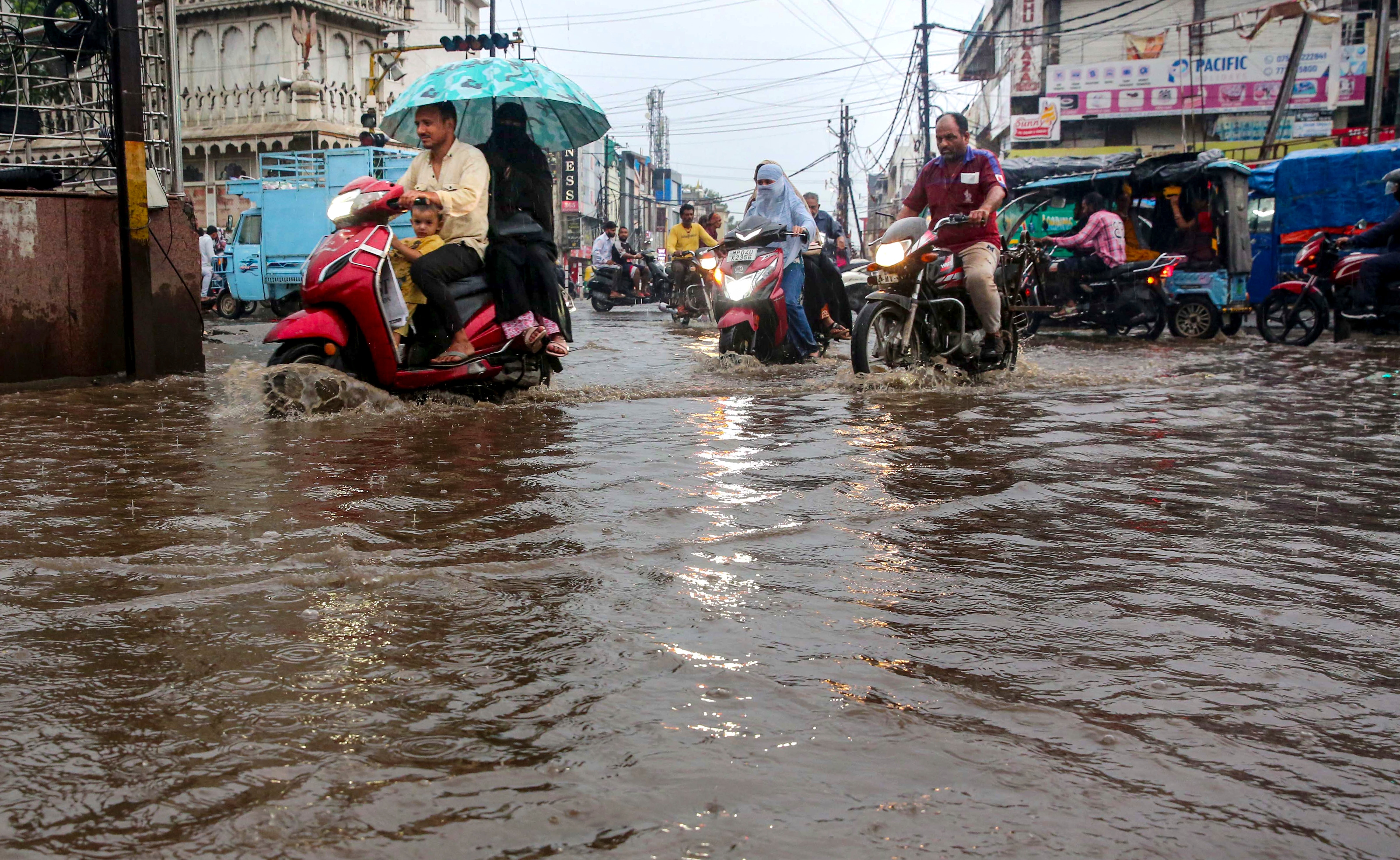 Vehicle move through a waterlogged street following heavy rains. (Photo: PTI)