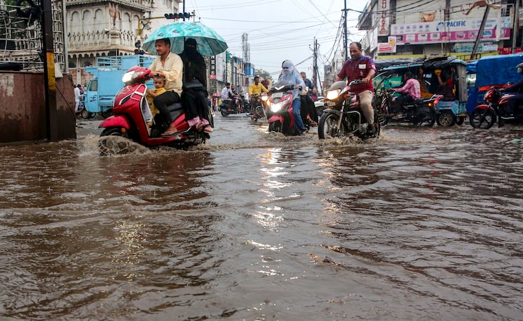 Vehicle move through a waterlogged street following heavy rains. (Photo: PTI)