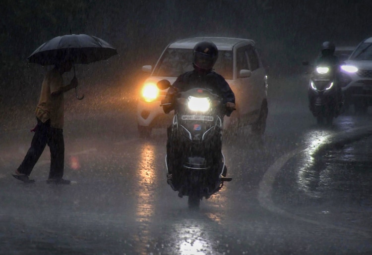 Vehicles ply on a road amid rain, in Bhopal. (Photo: PTI)