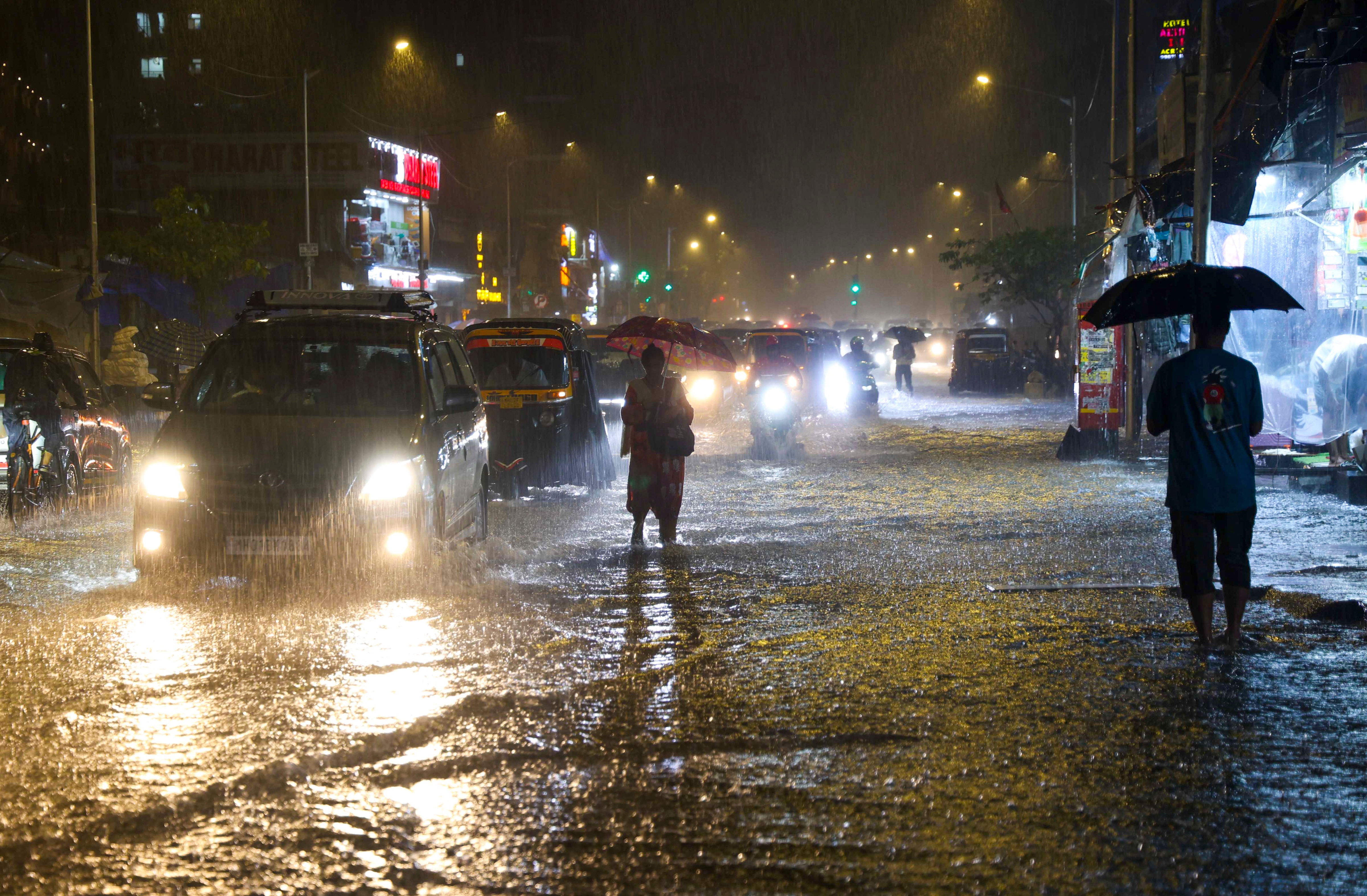 Commuters move through a waterlogged road amid heavy rain in Mumbai (Photo: PTI)