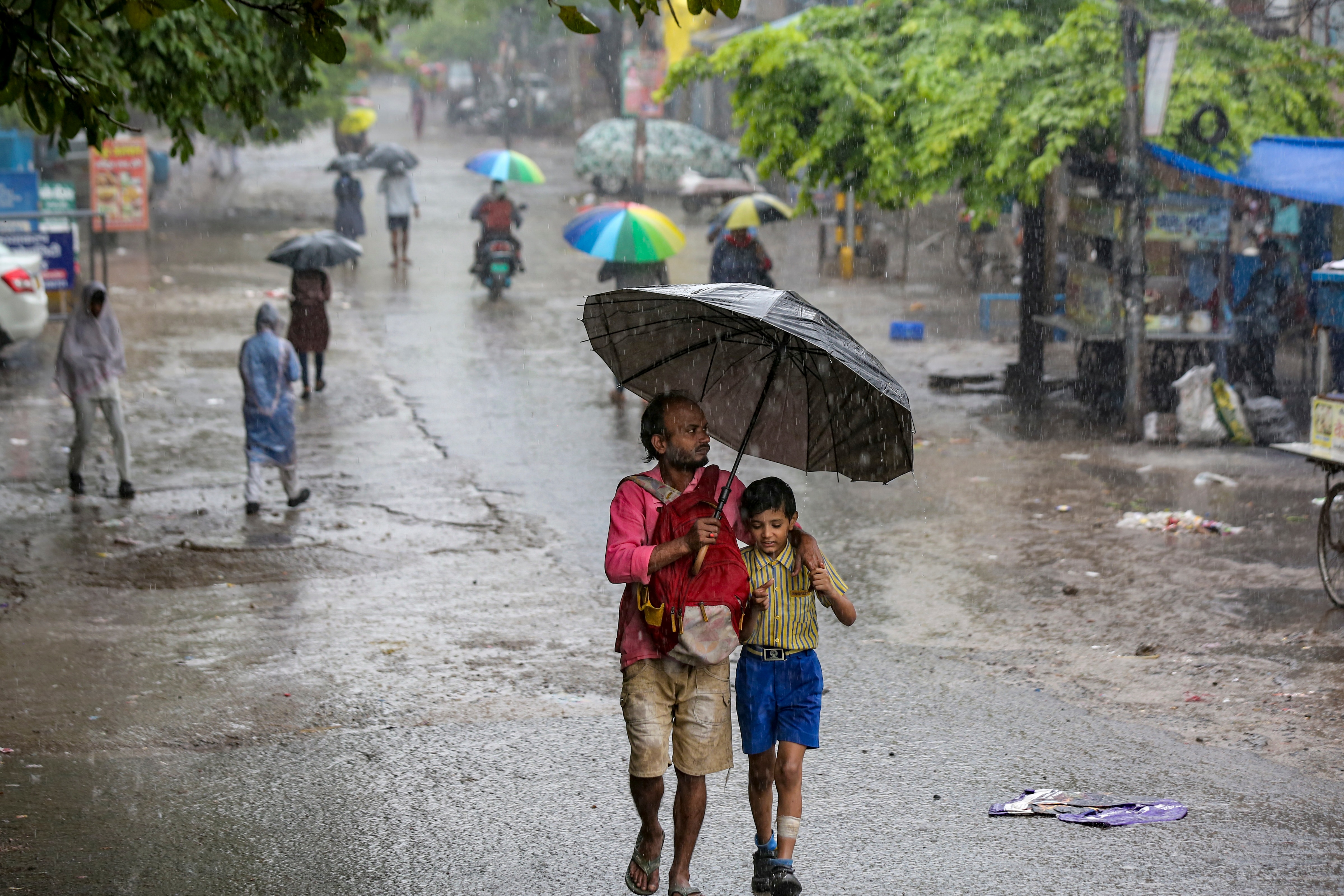 A man and his child walk amid heavy rain in New Delhi. (Photo: PTI)