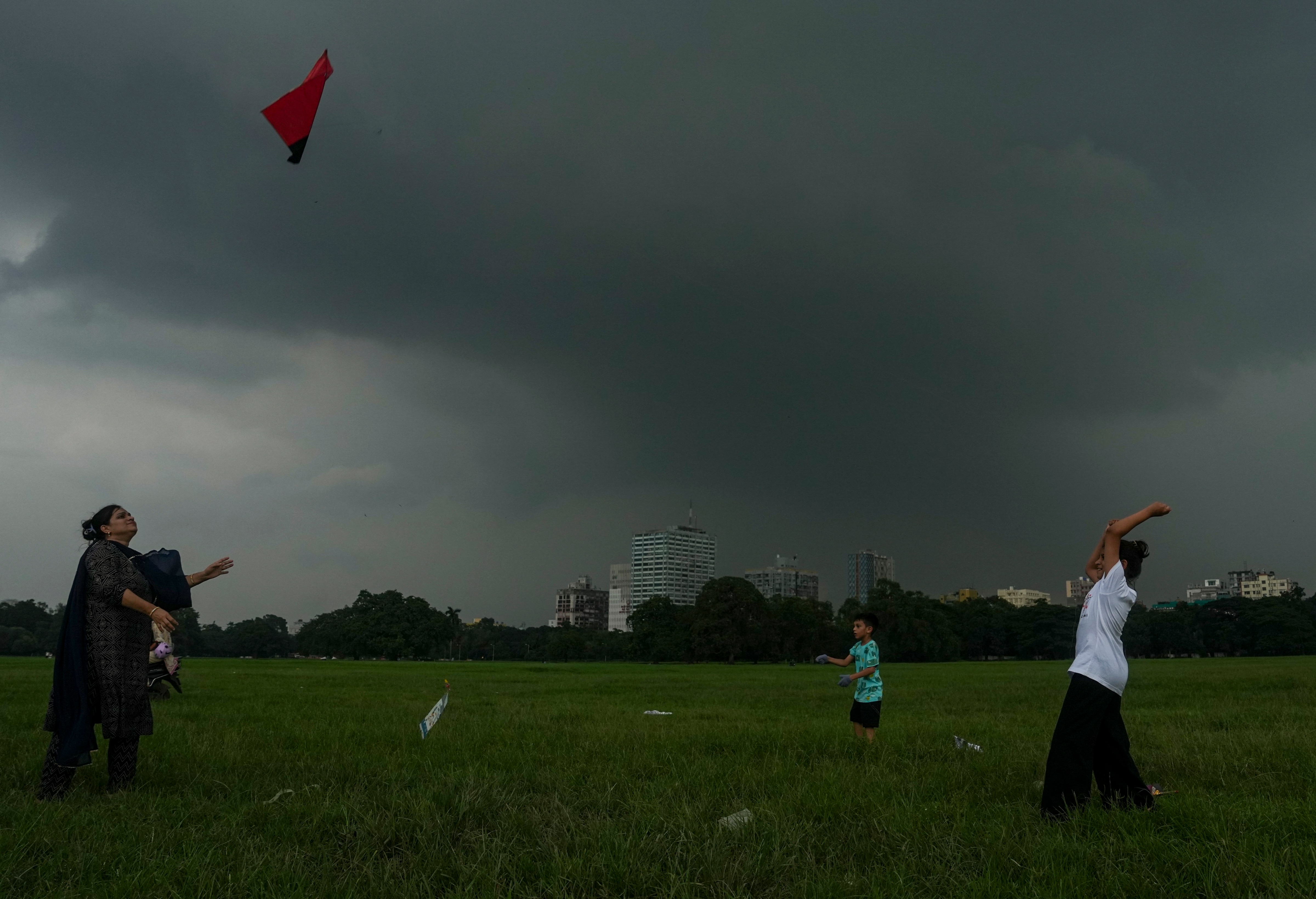 People fly kites as dark clouds hover, in Kolkata, West Bengal. (Photo: PTI)
