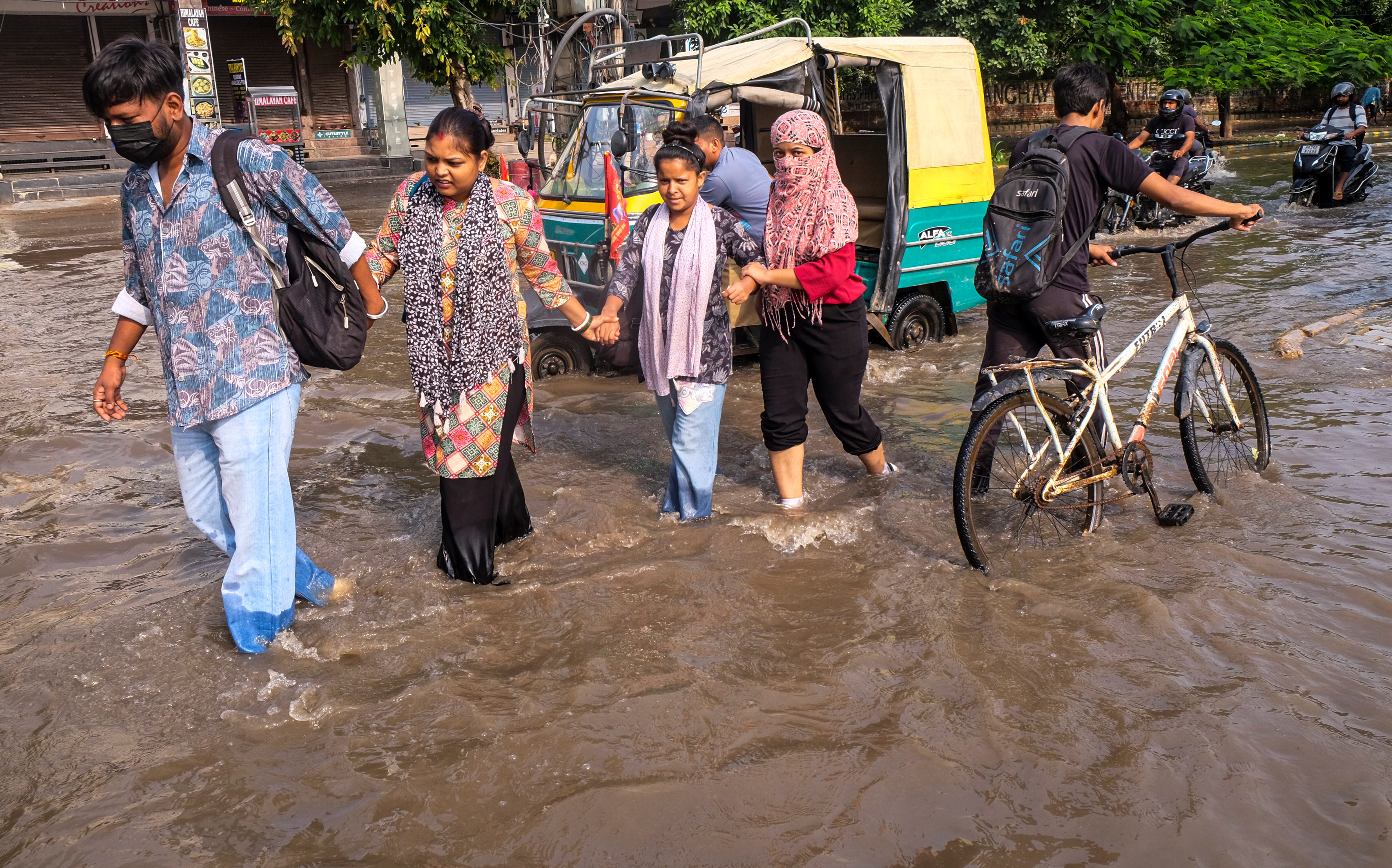 People wade through a waterlogged street in Gurugram. (Photo: PTI)