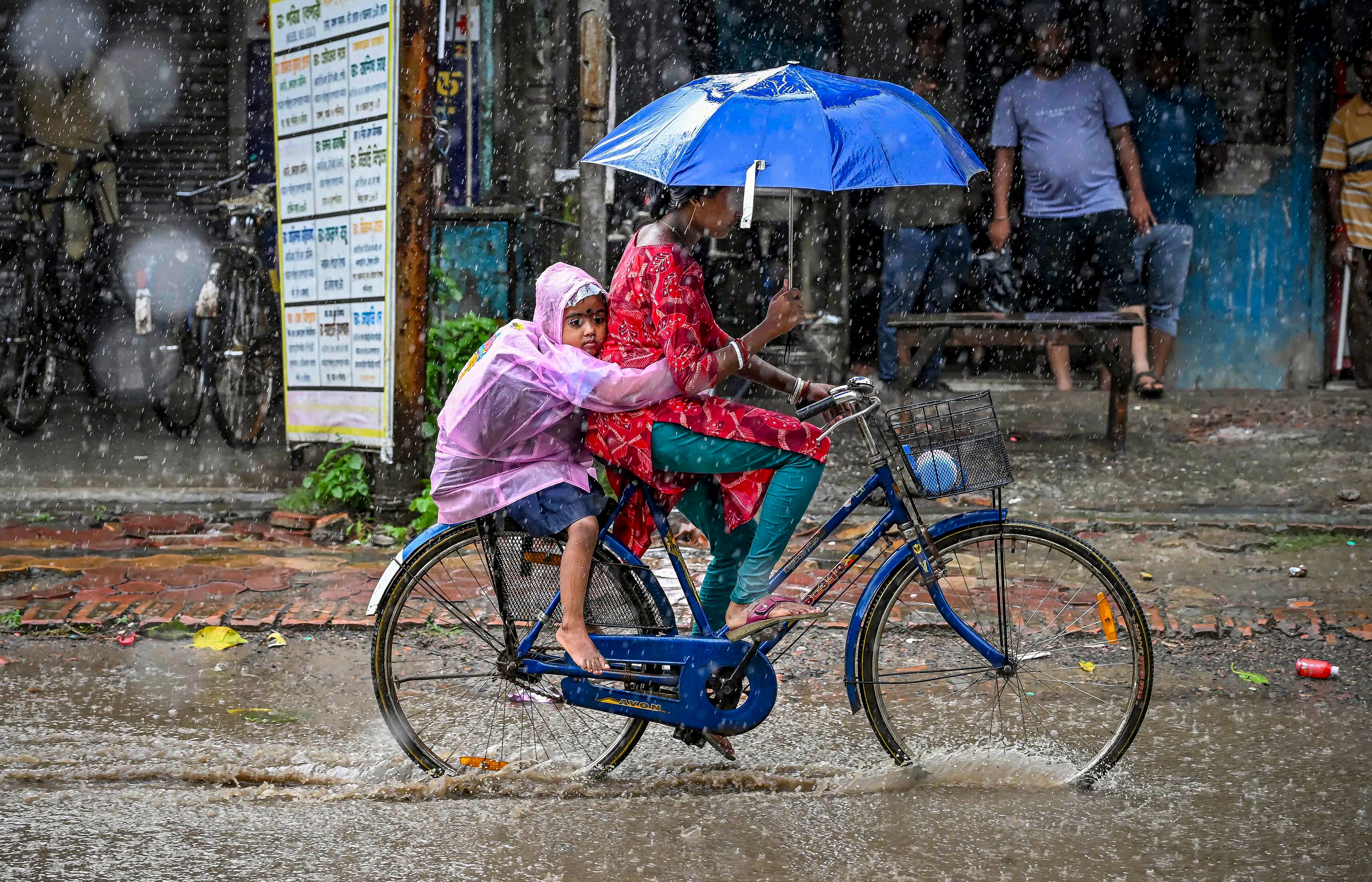 A woman rides a bicycle amid heavy rain. (Photo: PTI)