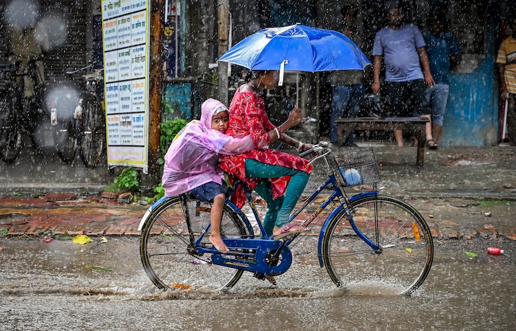 A woman rides a bicycle amid heavy rain. (Photo: PTI)