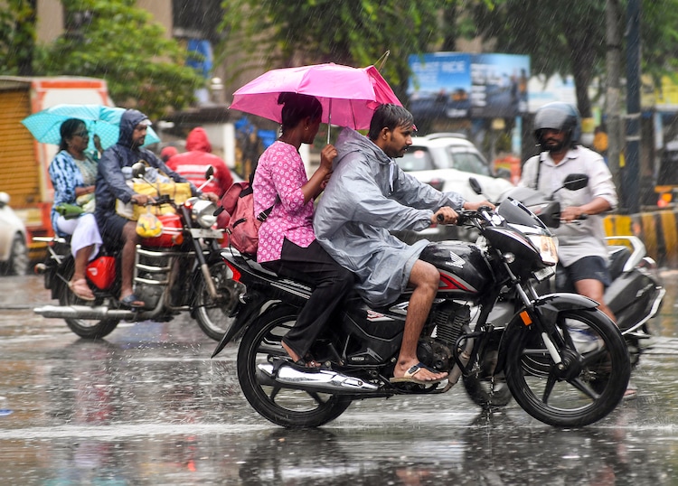 People ride a bike through heavy rain. (Photo: PTI)