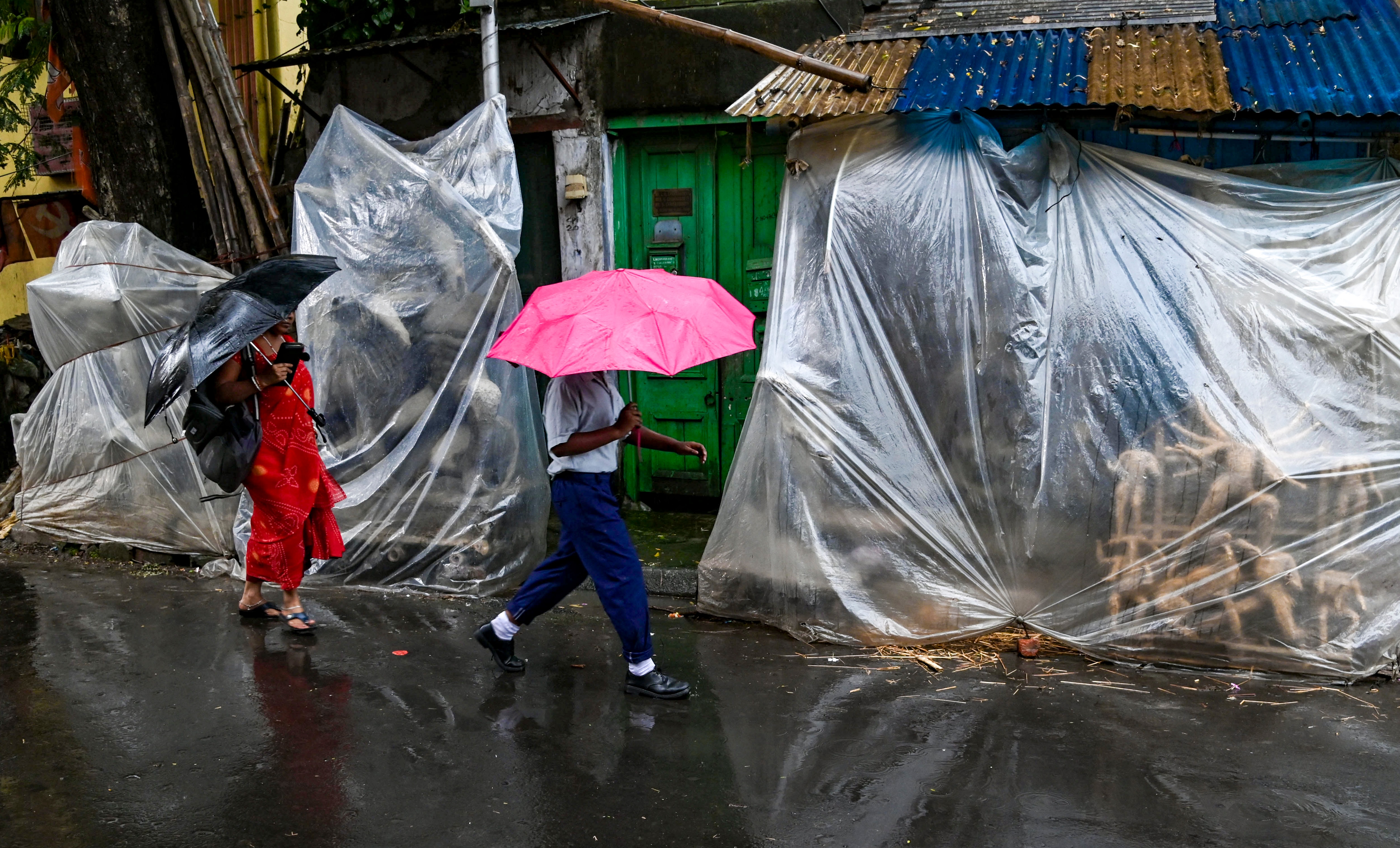 People walk amid rain in Kolkata. (Photo: PTI)