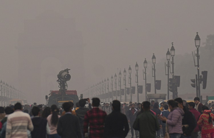 An anti-smog gun being used to curb air pollution as people visit the India Gate. (Photo: PTI)