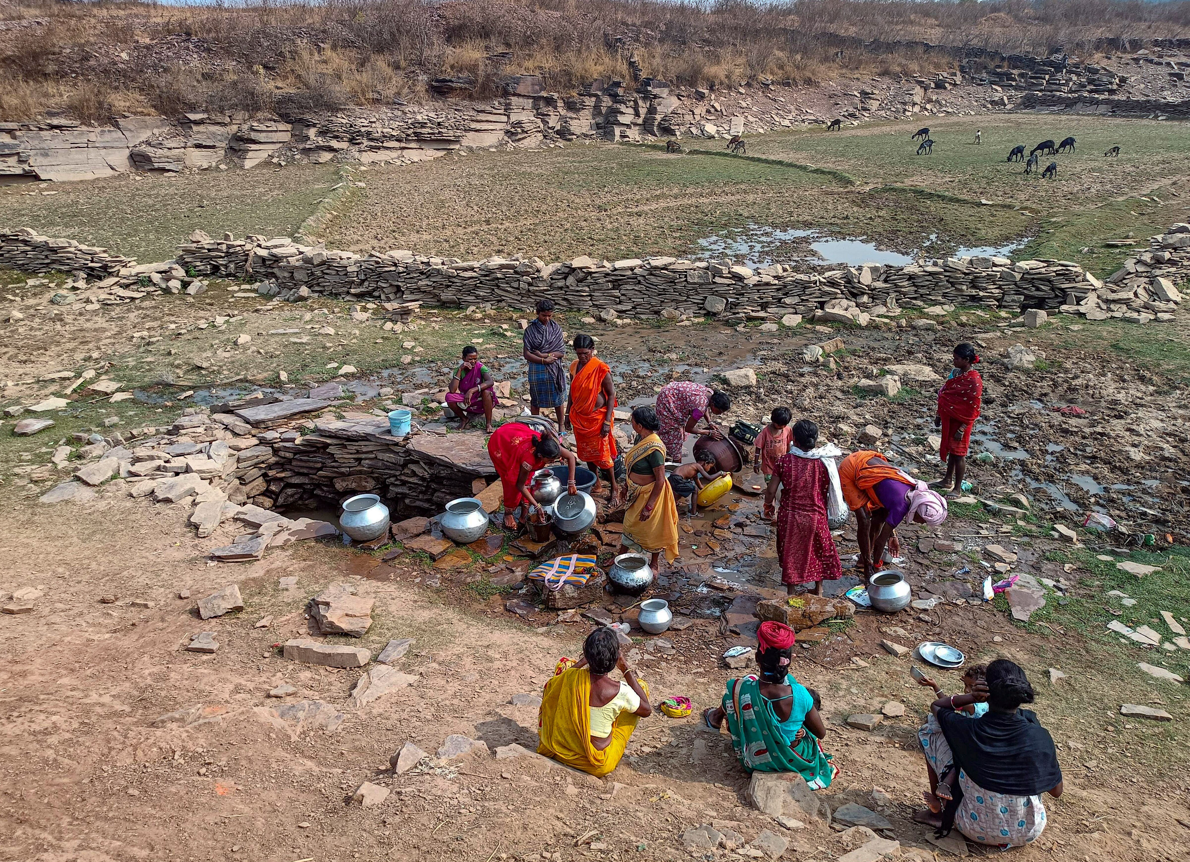 Women fill water in metal pots from a well on a hot day. (Photo: PTI)