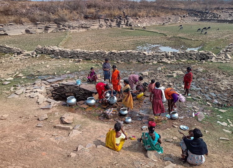Women fill water in metal pots from a well on a hot day. (Photo: PTI)