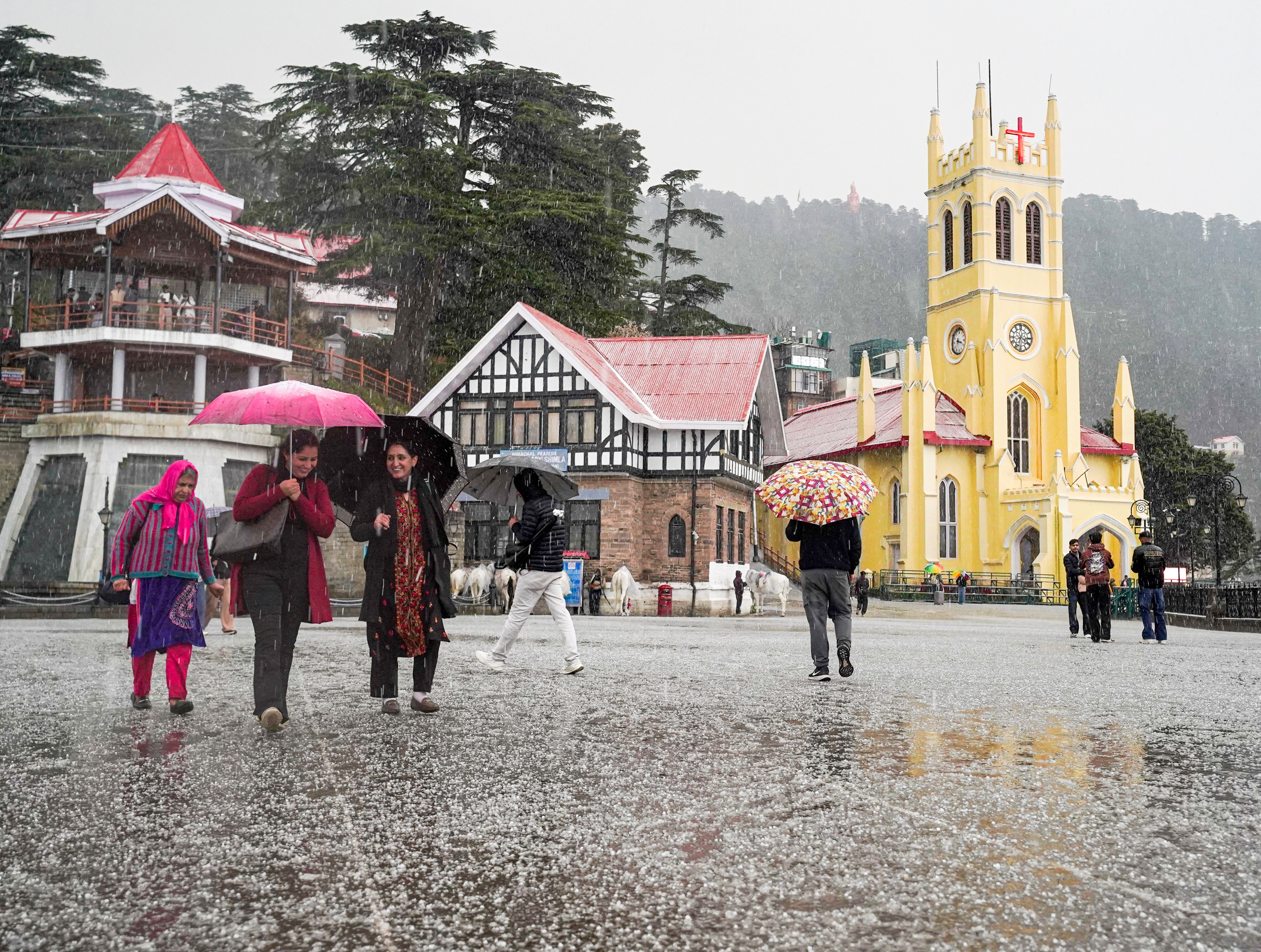 Pedestrians hold umbrellas during a hailstorm, in Shimla. (Photo: PTI)