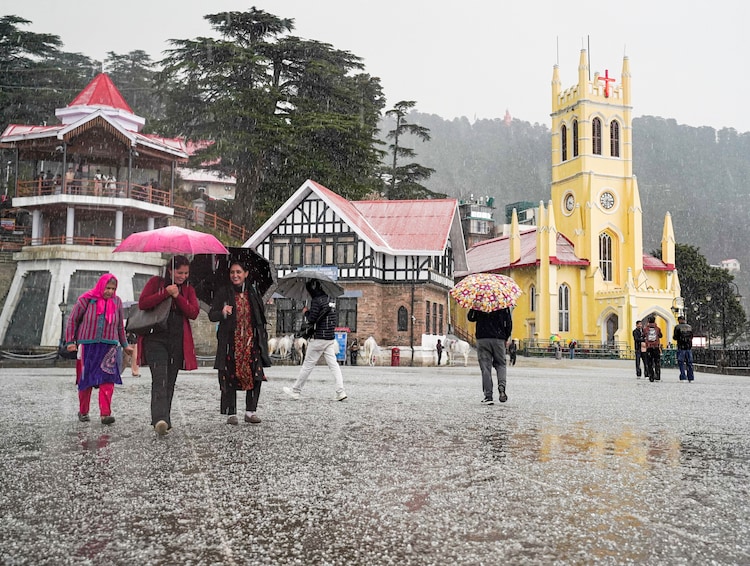 Pedestrians hold umbrellas during a hailstorm, in Shimla. (Photo: PTI)