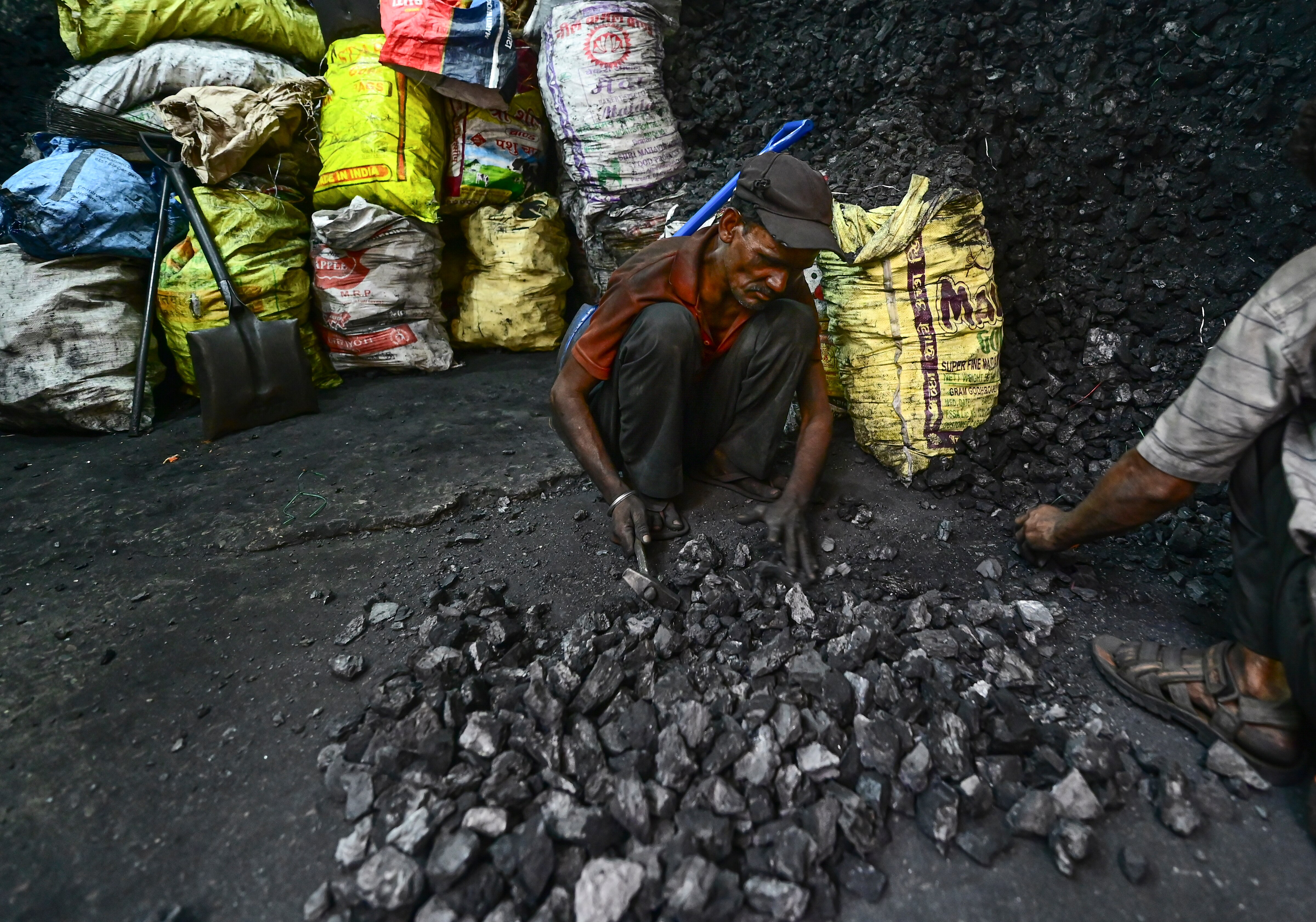 Workers break coal at a shop amid an LPG crisis, in Prayagraj. (Photo: PTI)