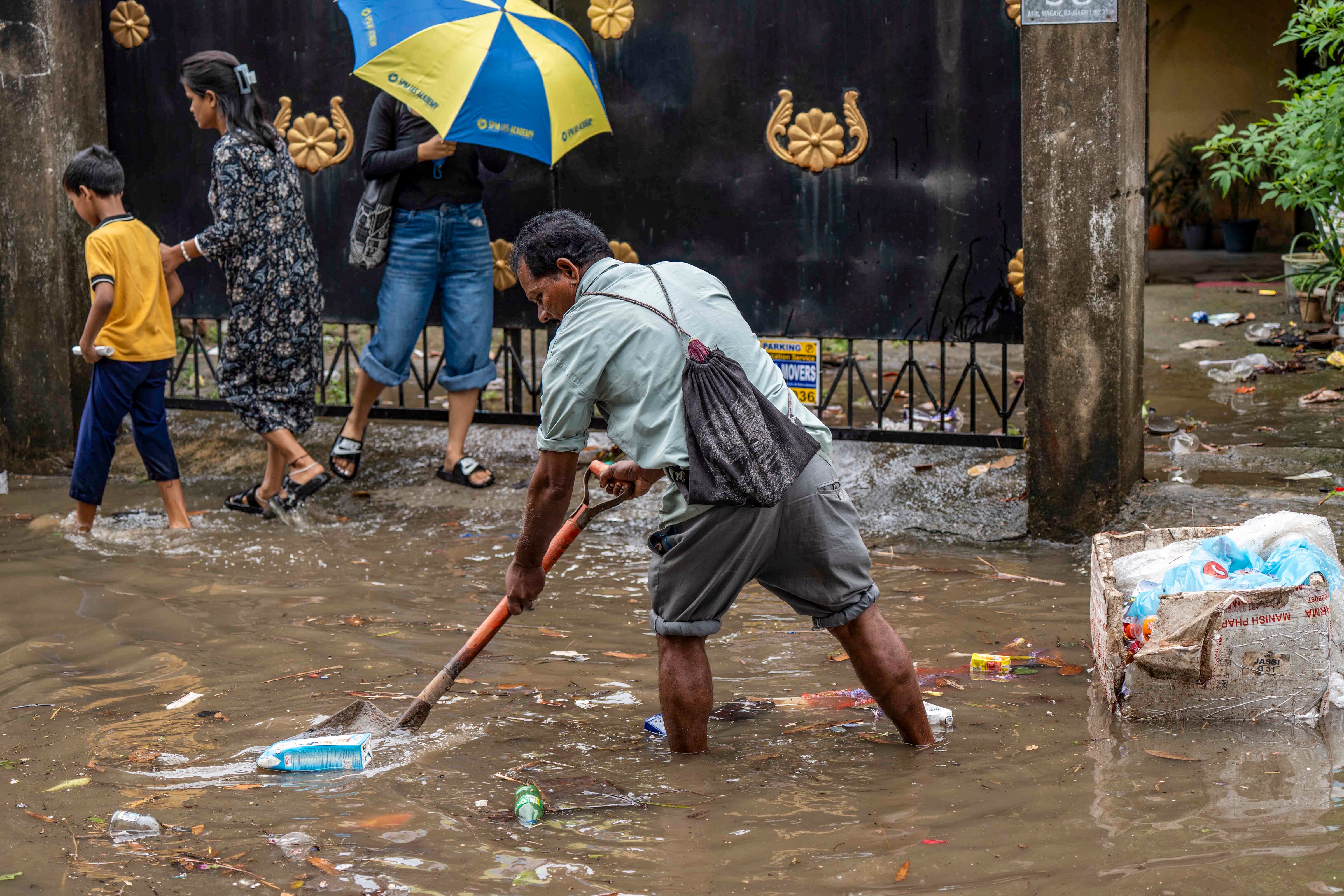 A man clears debris from a clogged drain following rainfall, in Guwahati, Assam. (Photo: PTI)