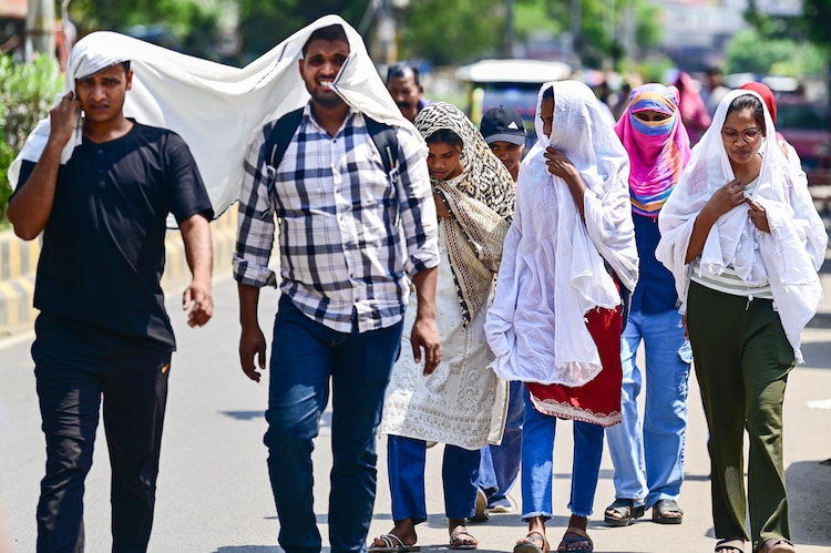 People cover themselves while walking on a hot summer day in Uttar Pradesh. (Photo: PTI)