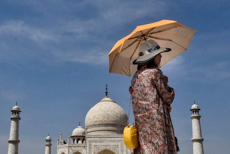 Tourists shield themselves from the scorching heat during their visit to the Taj Mahal, in Agra, Uttar Pradesh. (Photo: PTI)
