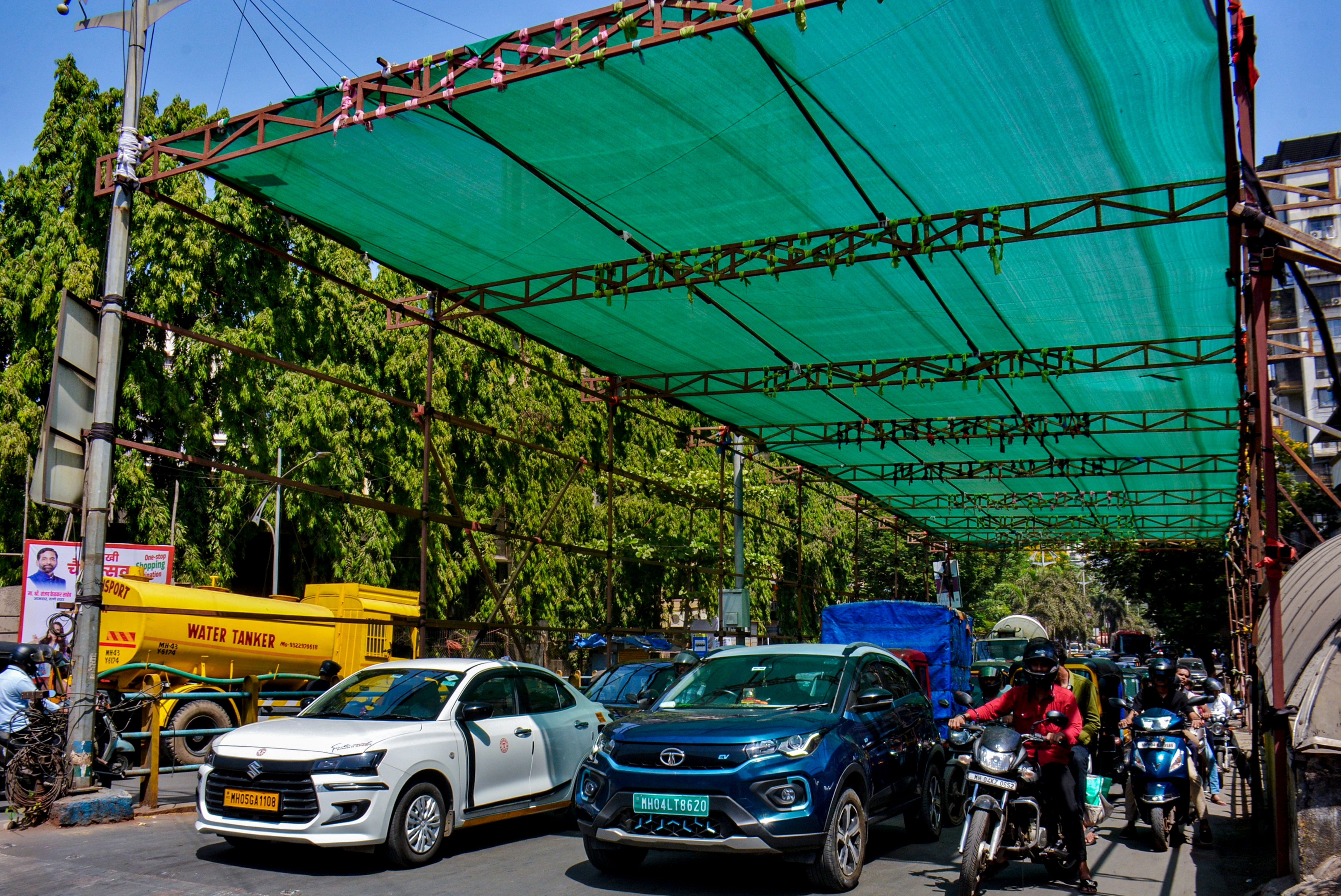 Vehicles ply under a green shade installed to provide relief from the heat in Thane. (Photo: PTI)