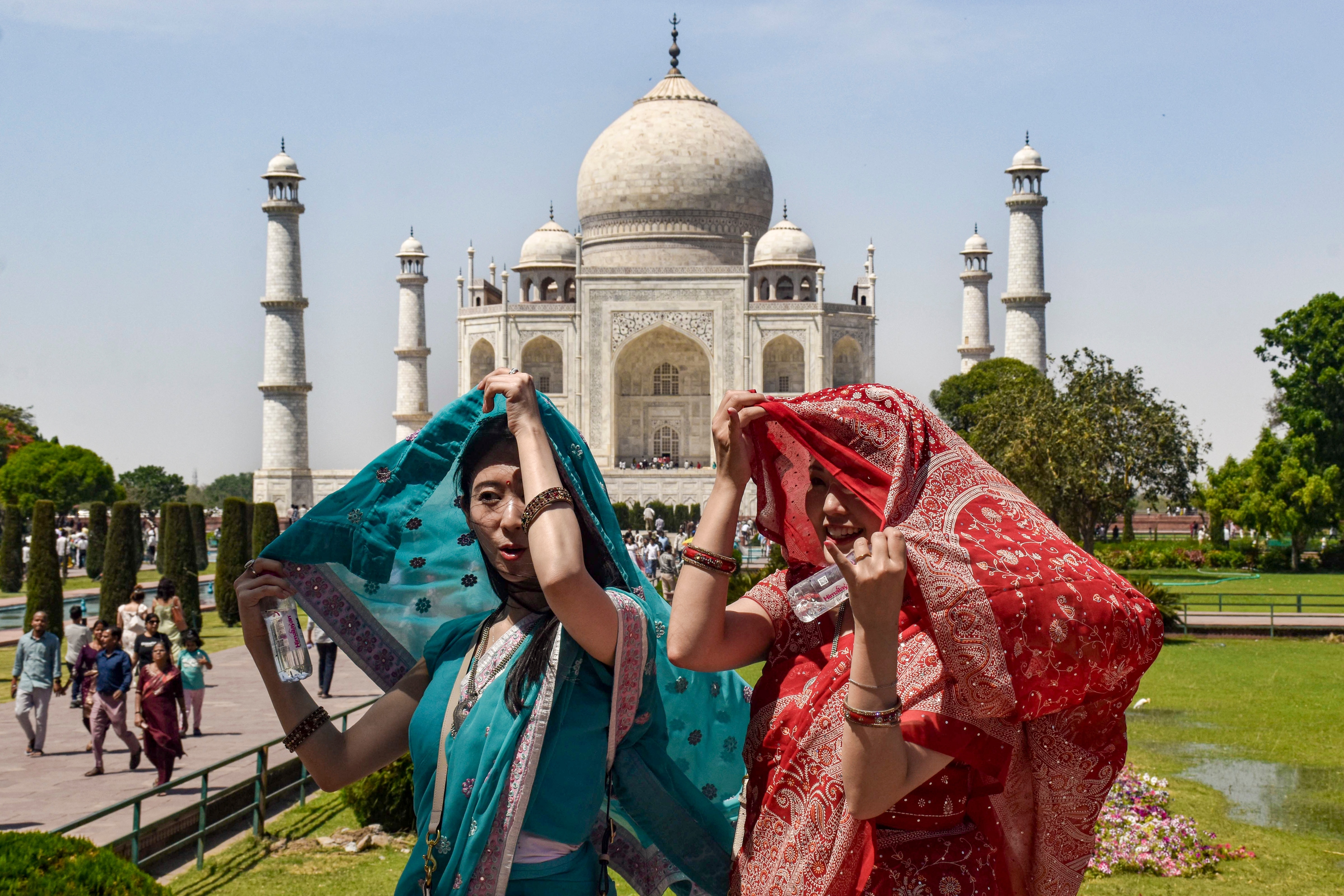 Visitors at Taj Mahal amid scorching heat, in Agra. (Photo: PTI)