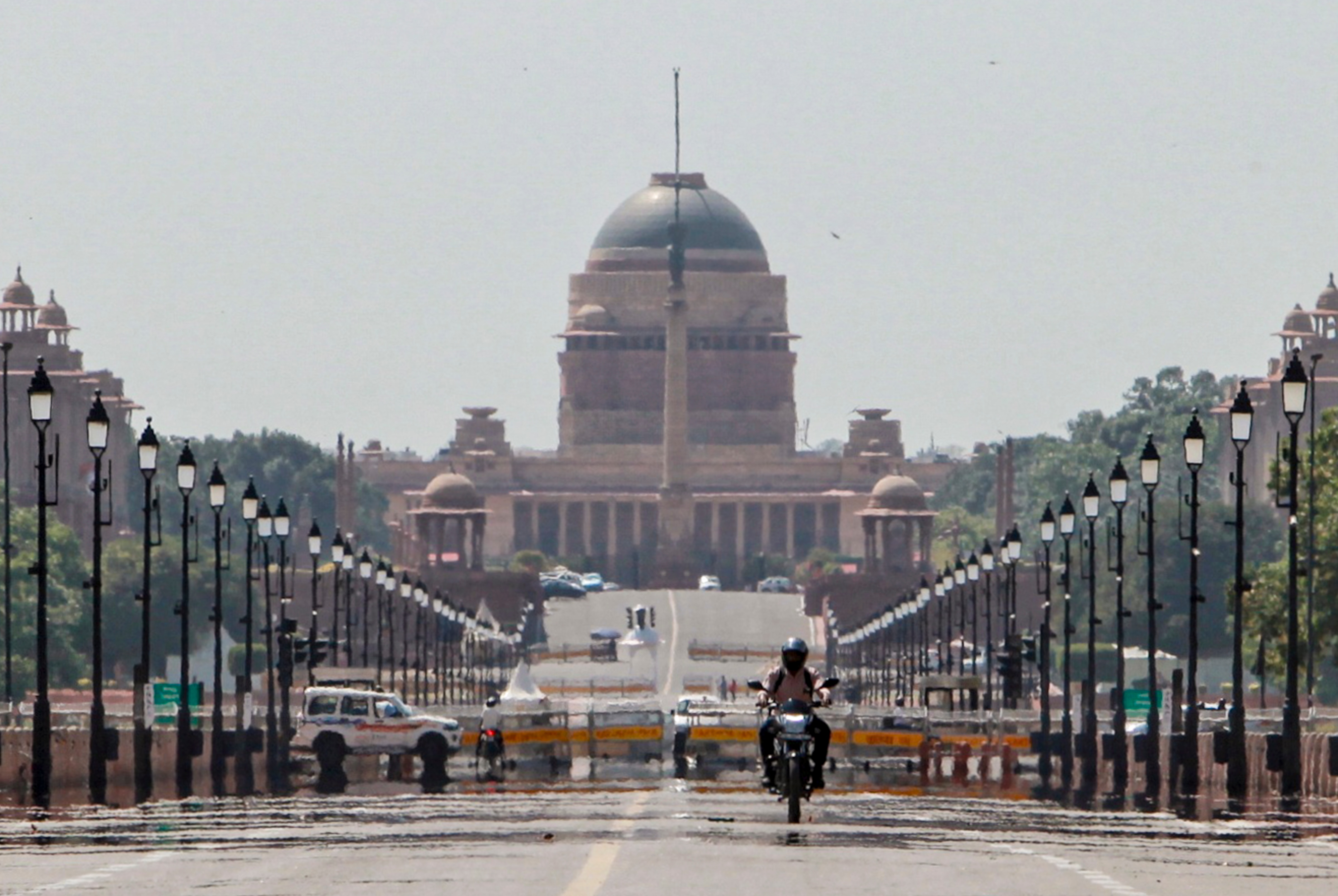 A biker cruises along the Kartavya Path as mirage appears on a hot summer day, in New Delhi. (Photo: PTI)