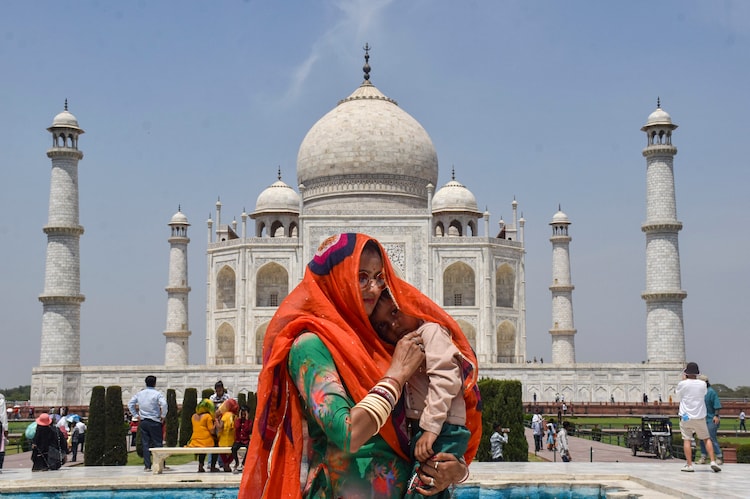 A woman covers herself and her child on a hot summer day in Agra, Uttar Pradesh. (Photo: PTI)