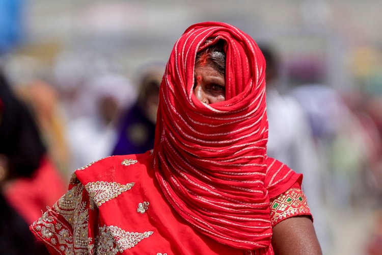 A woman covers her face to protect herself from the scorching sun on a hot day in Uttar Pradesh. (Photo: PTI)