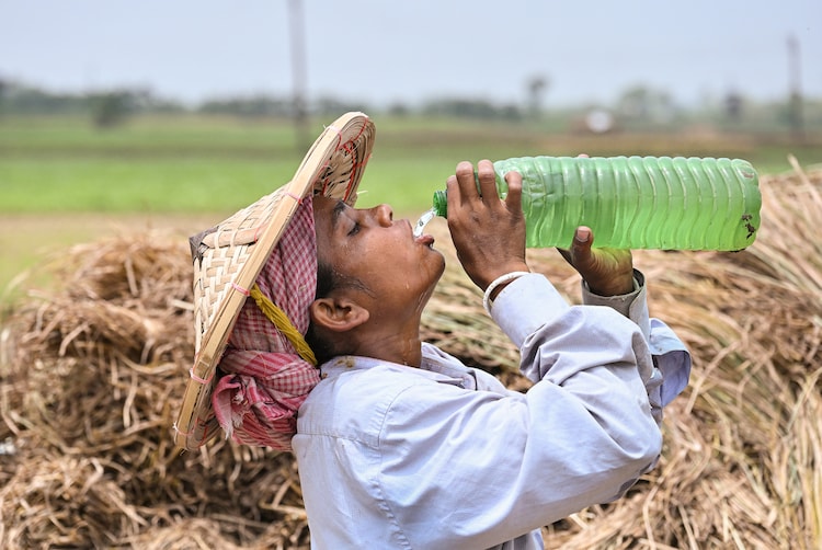 A labourer drinks water on a hot summer day at a field, in Nadia district, West Bengal. (Photo: PTI)