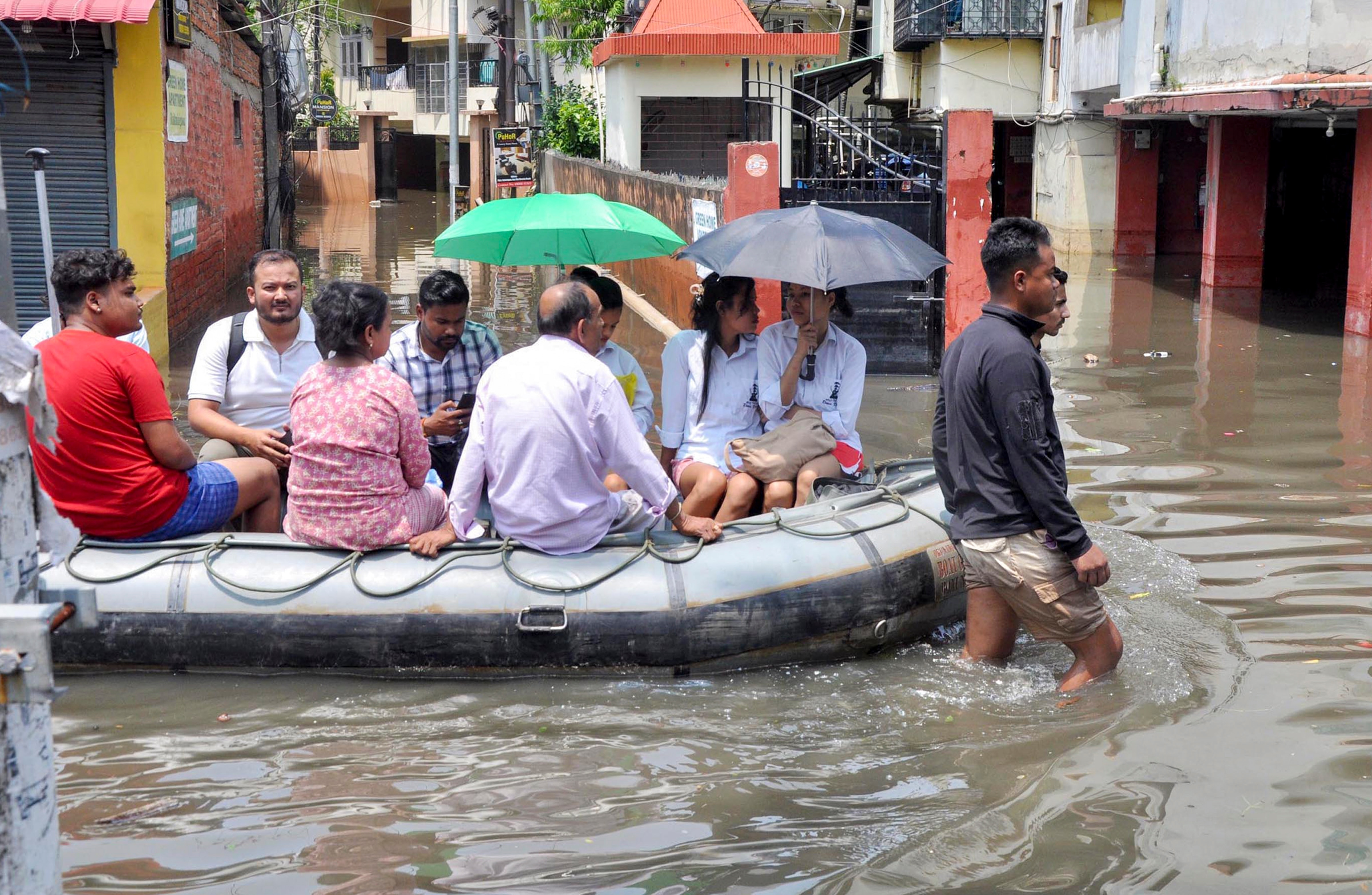 Rescue personnel evacuate residents by boat from a waterlogged area, in Guwahati, Assam. (Photo: PTI)