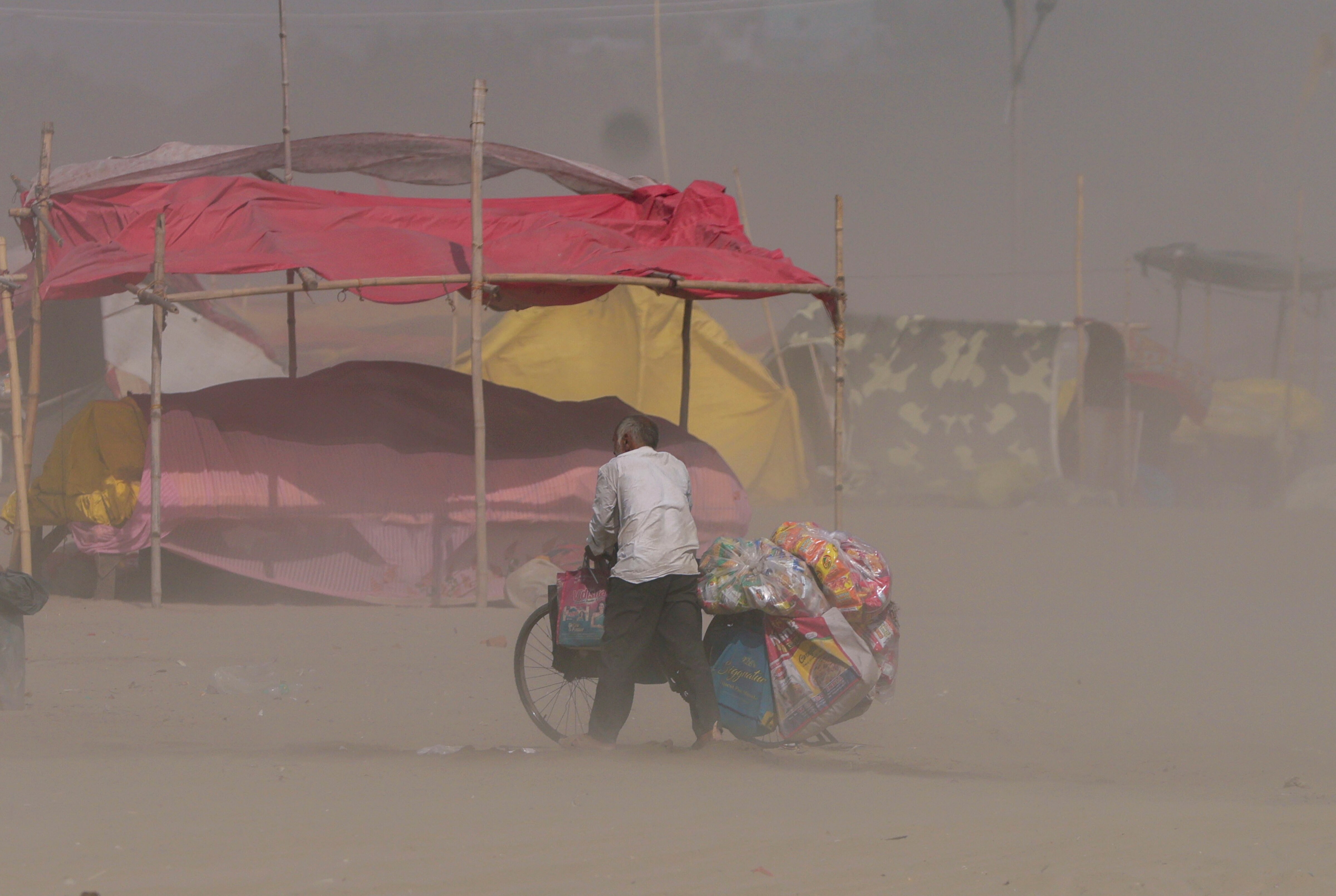 A cyclist moves through dust on a hot summer day, in Uttar Pradesh. (Photo: PTI)