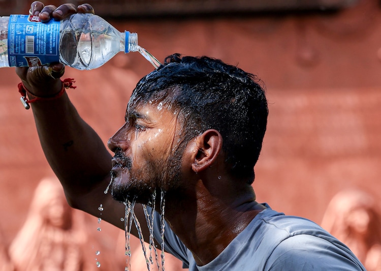 A man pours water on himself to cool down amid a heatwave in Jammu. (Photo: PTI)
