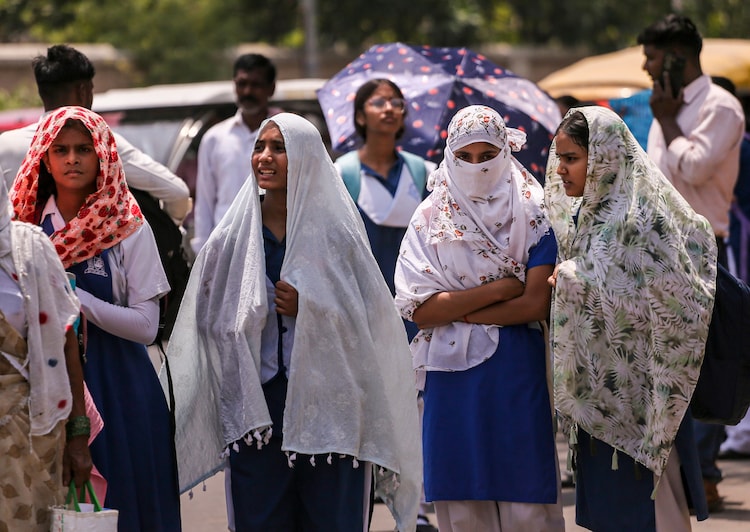 People shield themselves from heat on a hot day in Prayagraj. (Photo: PTI)