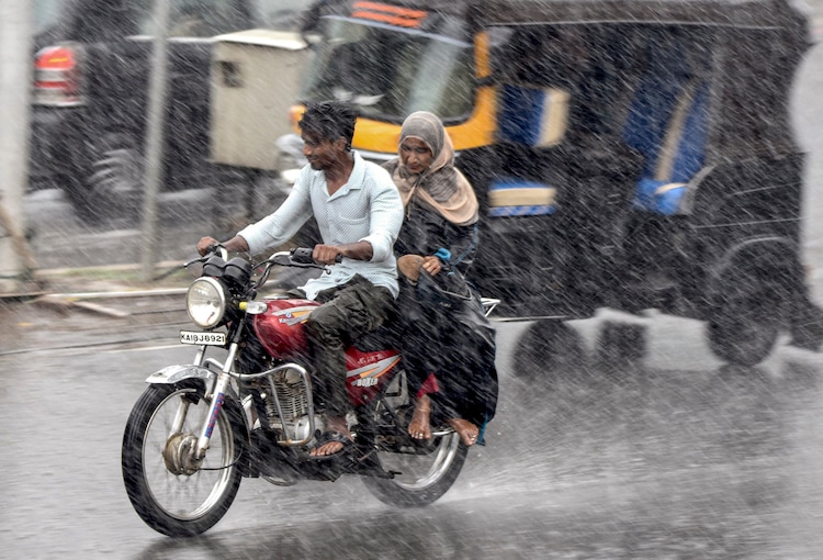 Commuters make their way amid heavy rain. (Photo: PTI)