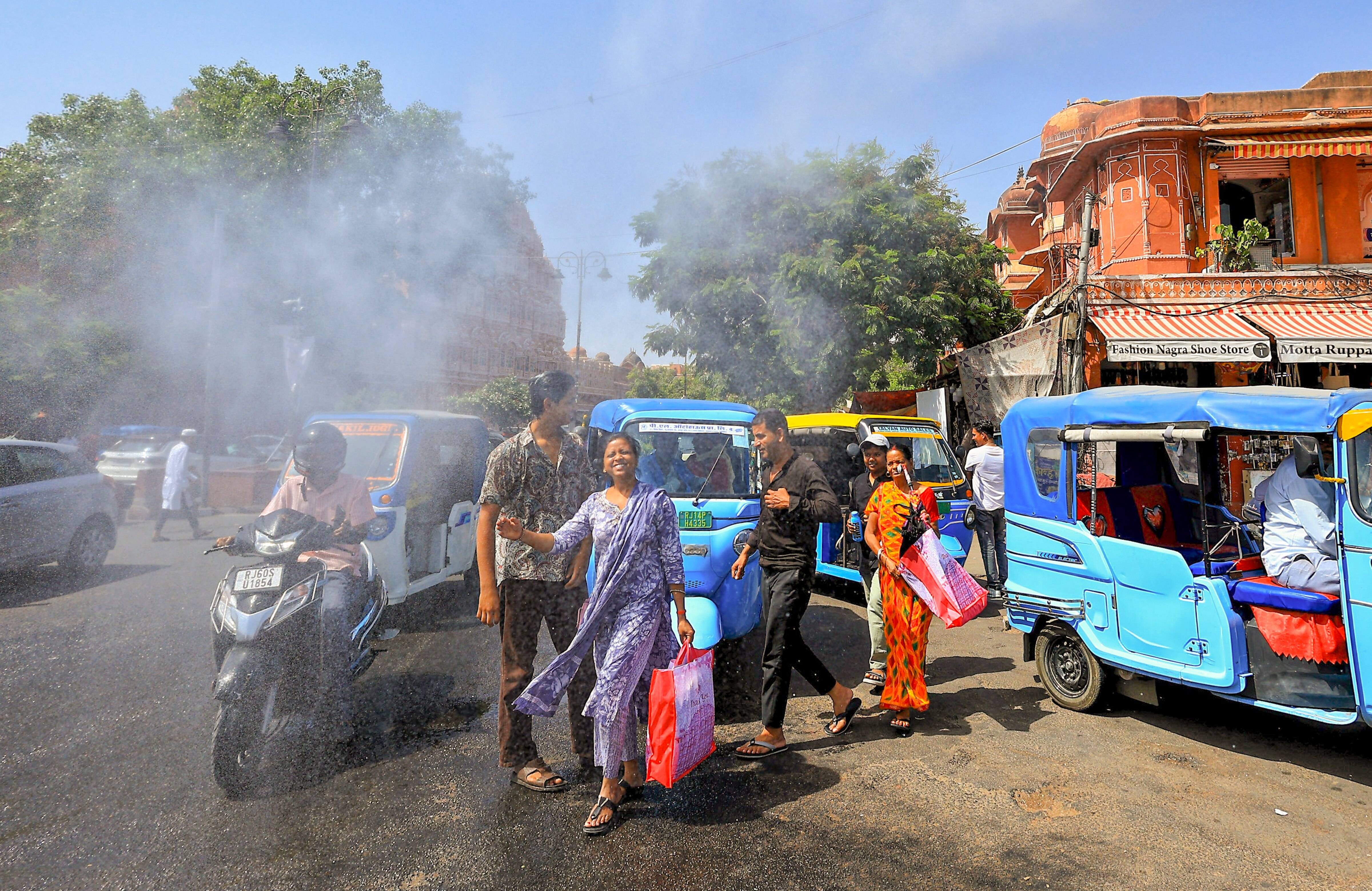 People try to beat the heat with sprinkled water in Jaipur. (Photo: PTI)