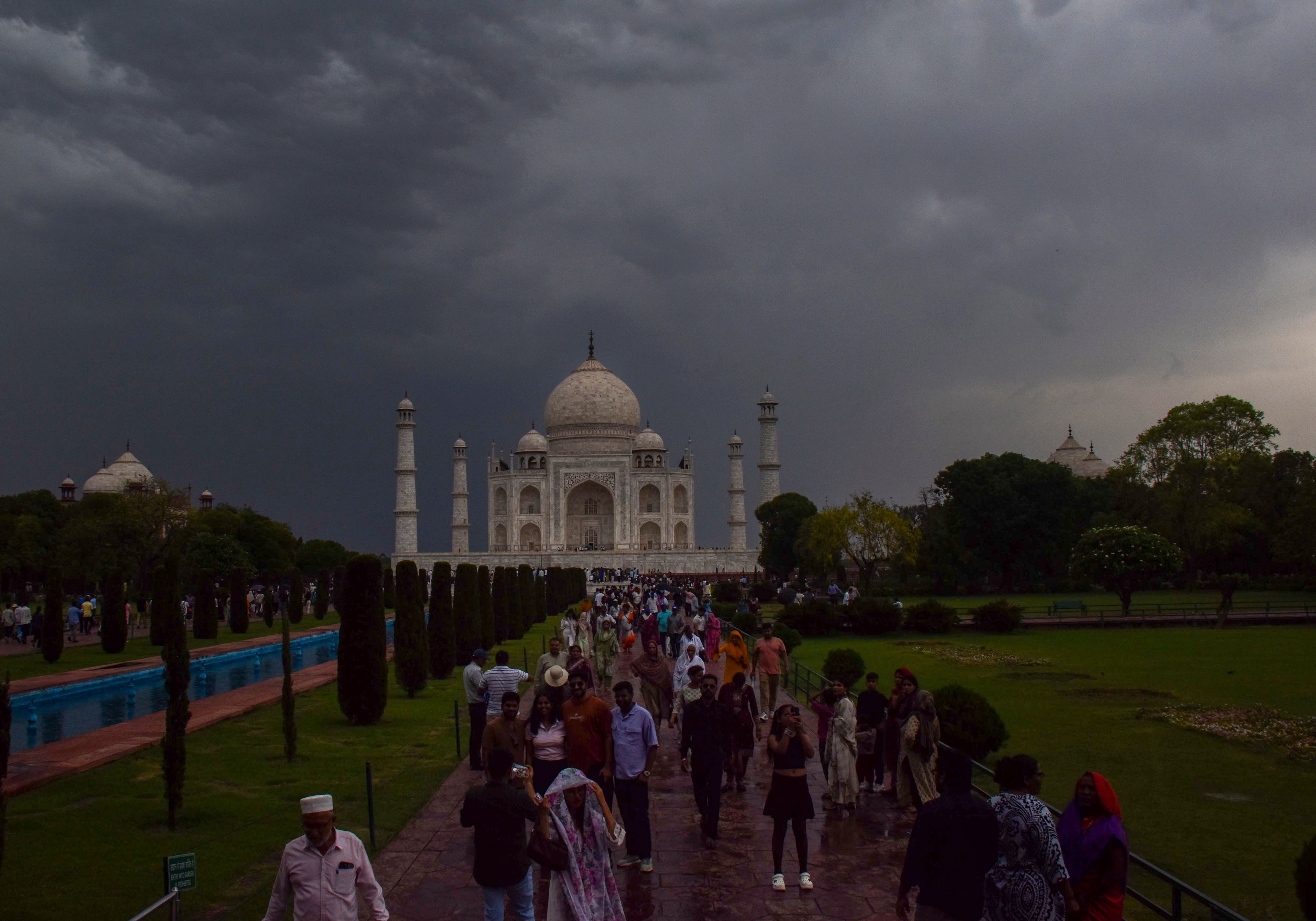 People gather at the Taj Mahal on a cloudy and rainy day. (Photo: PTI)