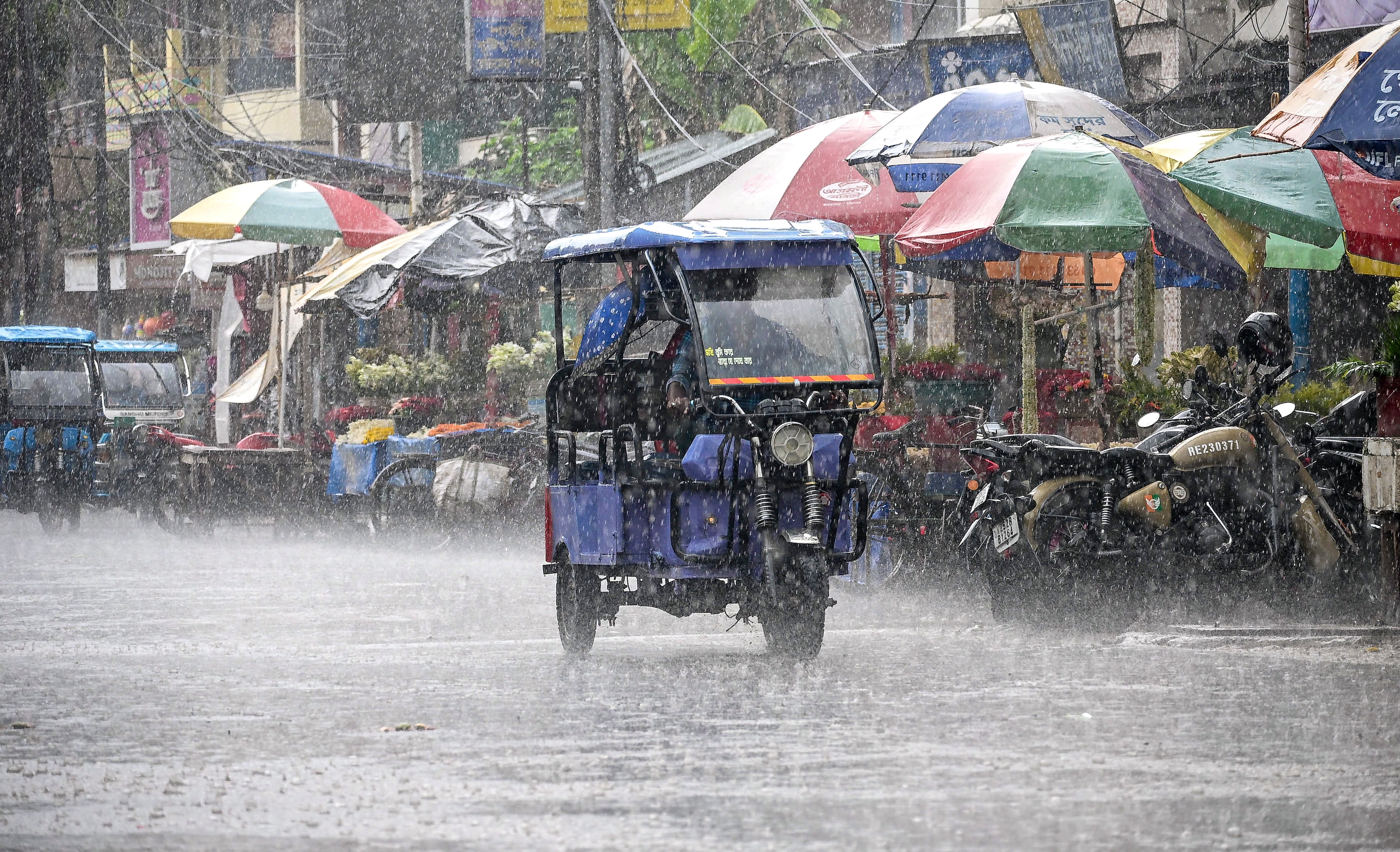 An e-rickshaw moves along a street during heavy rain, in Nadia district, West Bengal. (Photo: PTI)