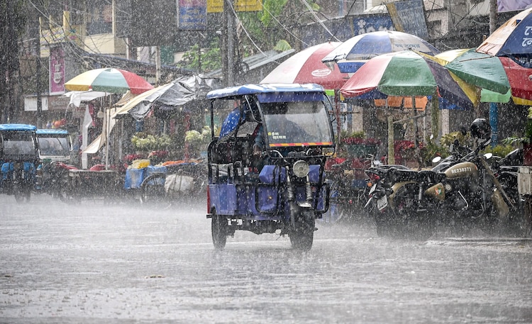 Rain and hail on its way: May to grow more erratic, temperatures to drop An e-rickshaw moves along a street during heavy rain, in Nadia district, West Bengal. (Photo: PTI)