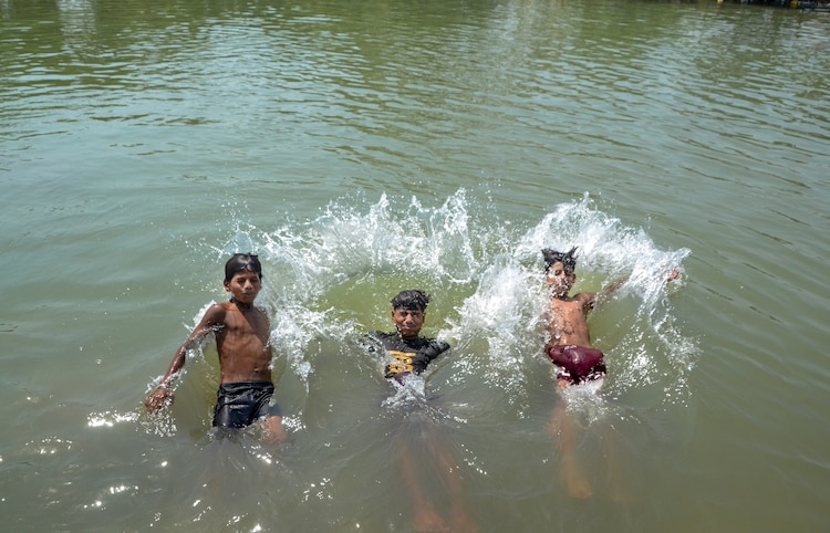 Rain and hail on its way: May to grow more erratic, temperatures to drop Children take bath in a canal on a hot summer day, in Kanpur, Uttar Pradesh. (Photo: PTI)