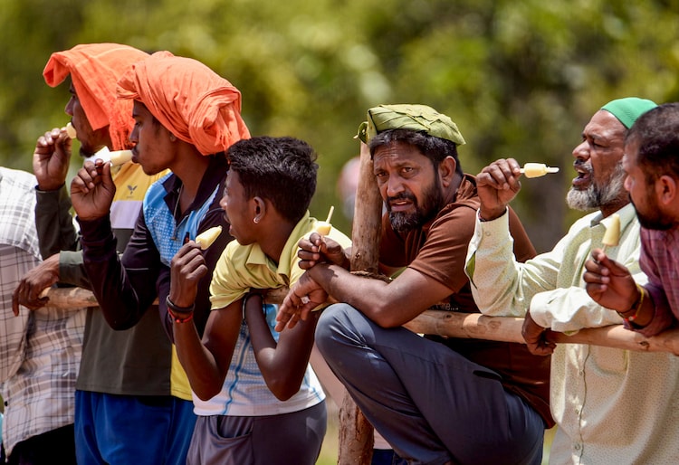 People eat an ice candy on a hot day in Karnataka. (Photo: PTI)