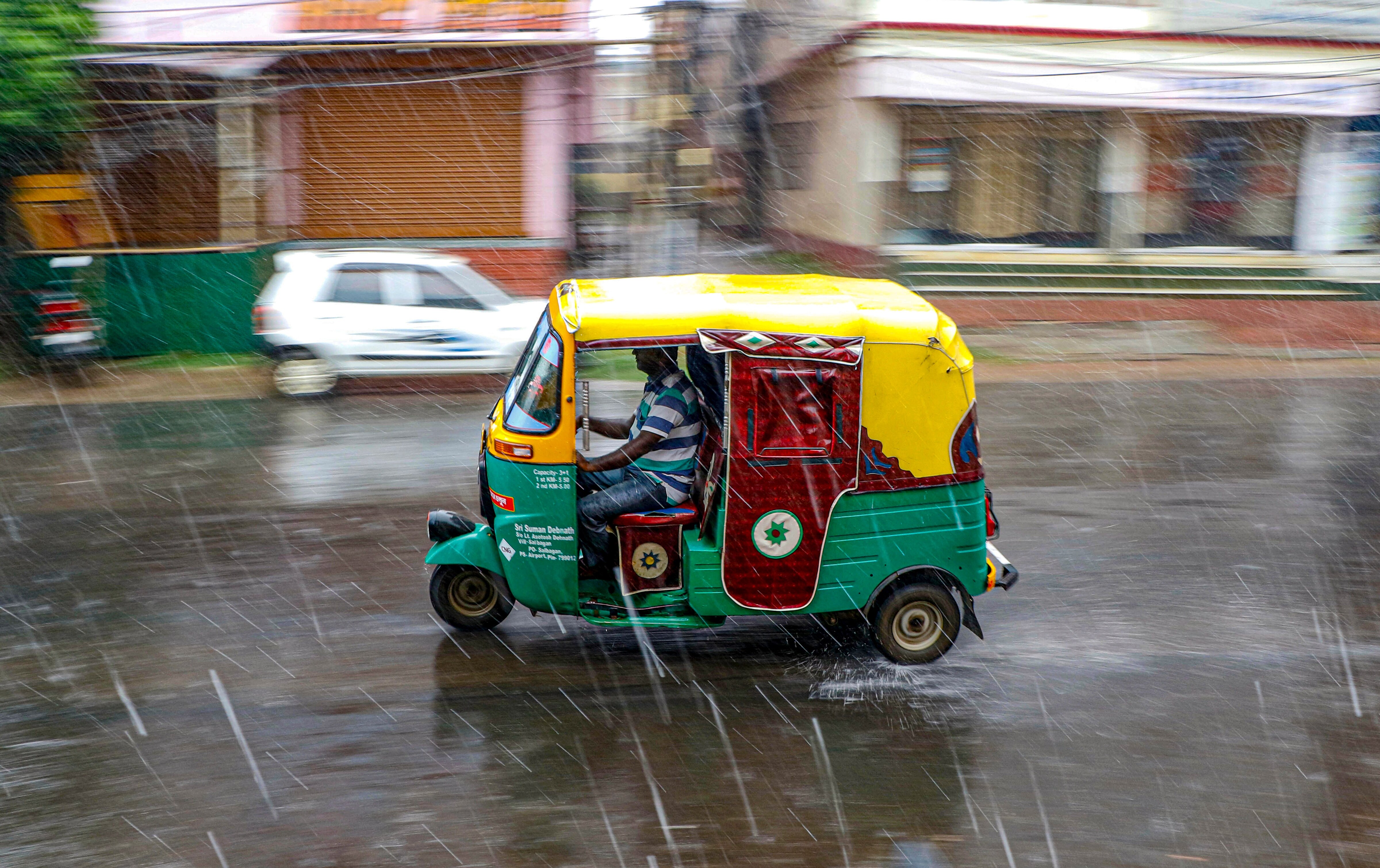 An auto rickshaw moves on a street during rain, in Agartala. (Photo: PTI)