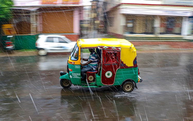 An auto rickshaw moves on a street during rain, in Agartala. (Photo: PTI)