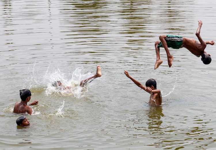 Boys play in a pond to beat the heat in West Bengal. (Photo: PTI)