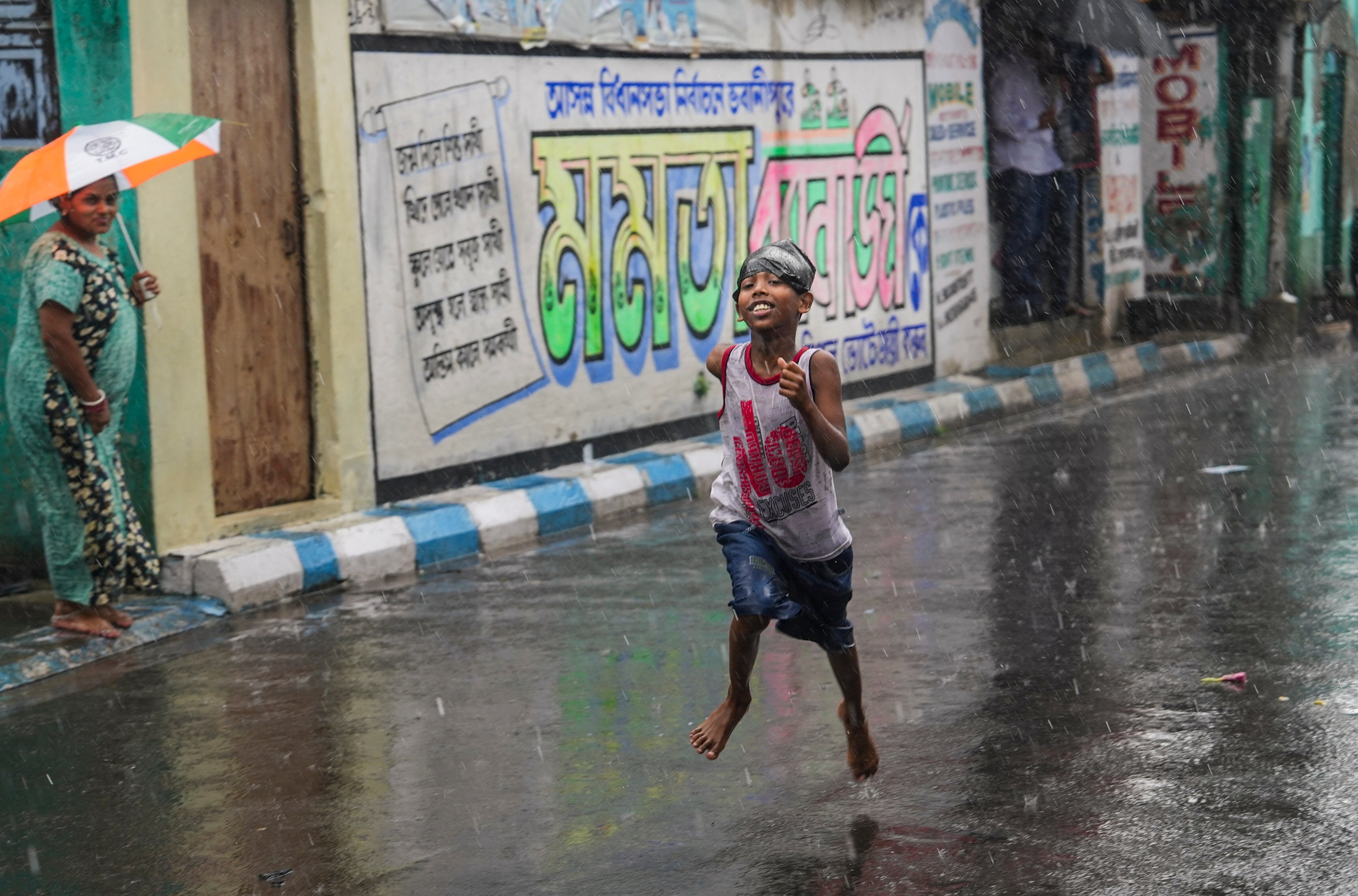 A boy runs amid rain, in Kolkata. (Photo: PTI)