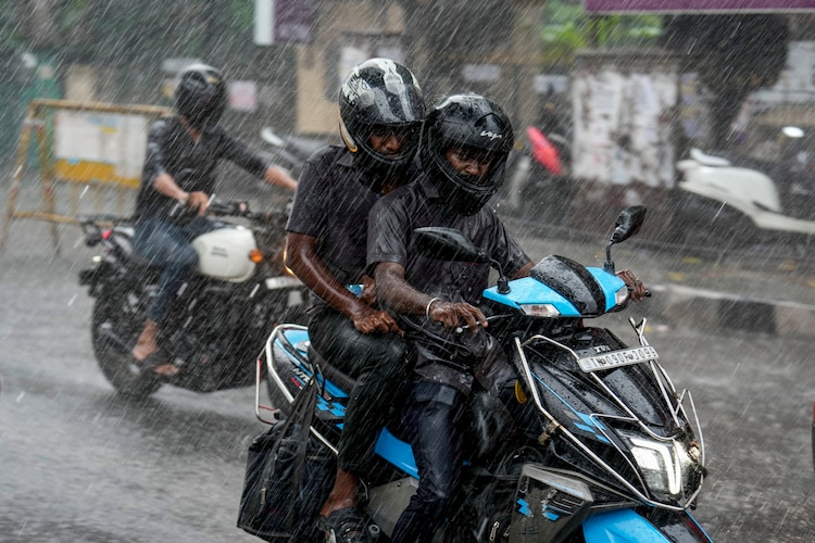 Commuters make their way during rainfall, in Chennai. (Photo: PTI)